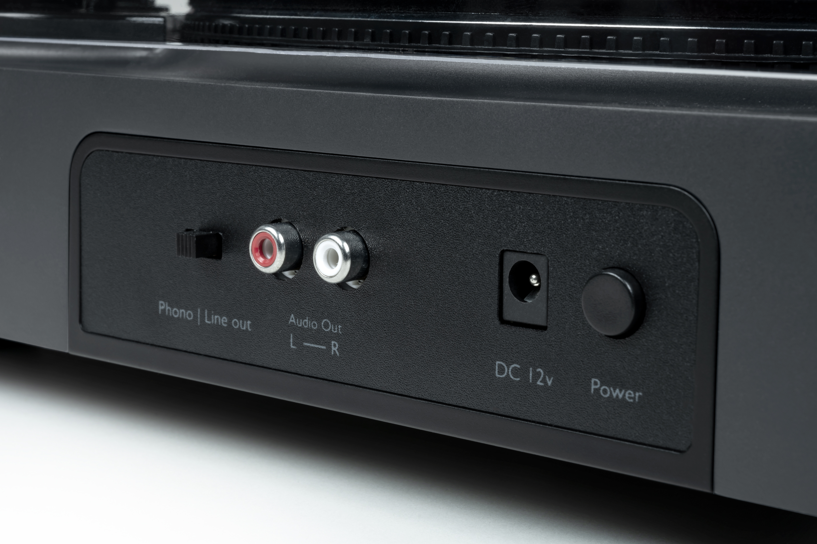Primer plano de la parte trasera de un tocadiscos con phono, salida de línea, CC y entrada de alimentación.