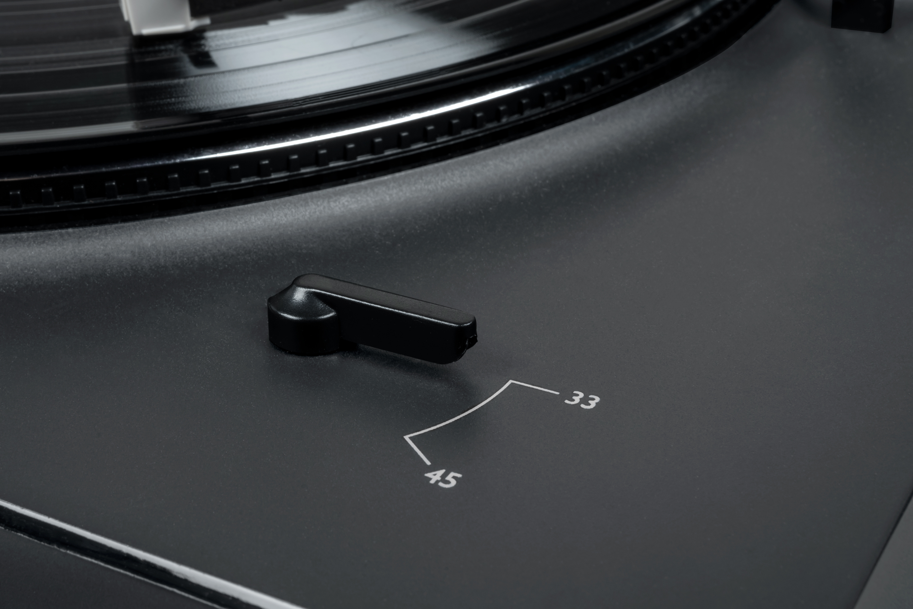 Primer plano de un tocadiscos negro con el selector de velocidad en 33.