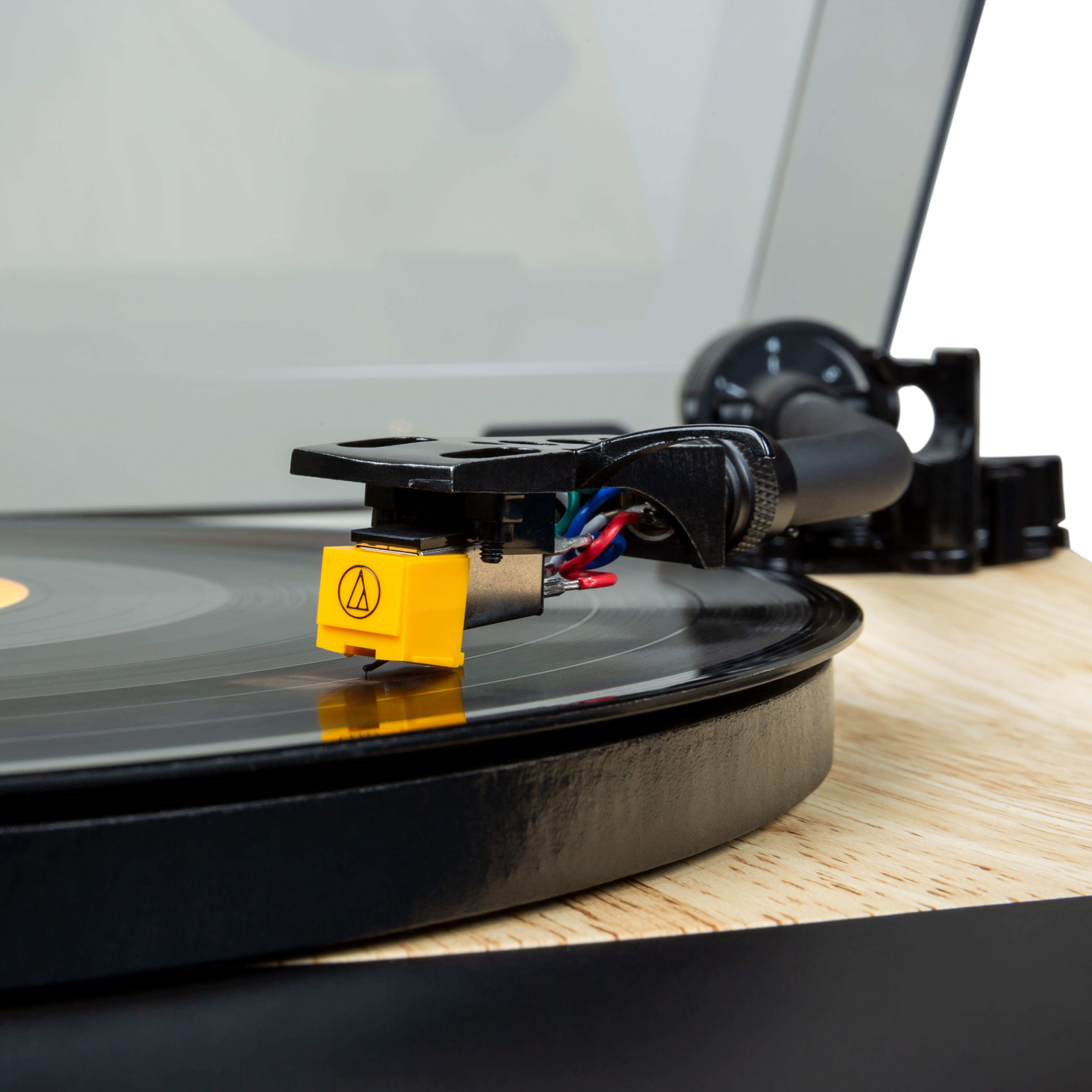Primer plano de un tocadiscos. Tocadiscos negro con aguja amarilla y disco.