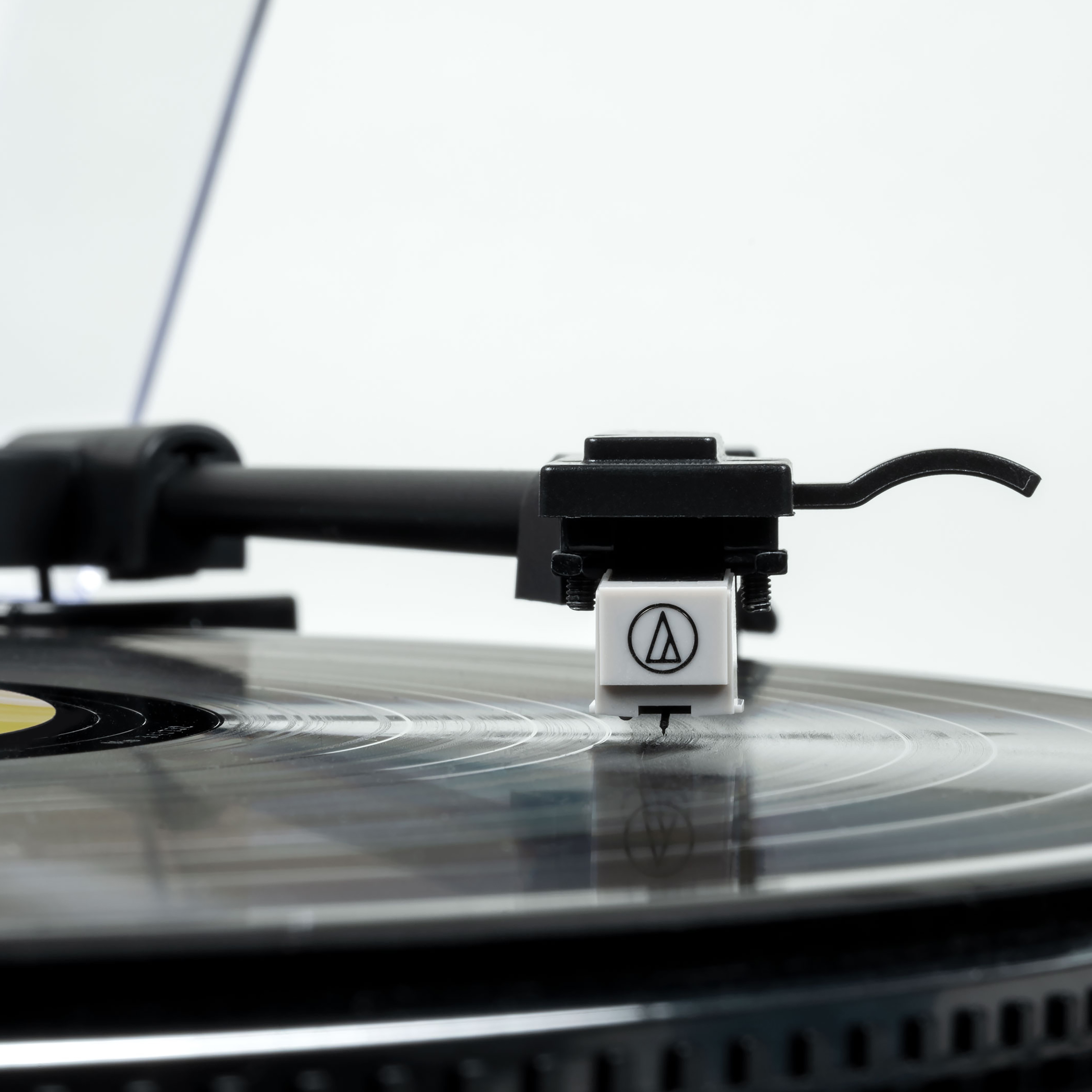 Zbliżenie igły gramofonowej na czarnej płycie.