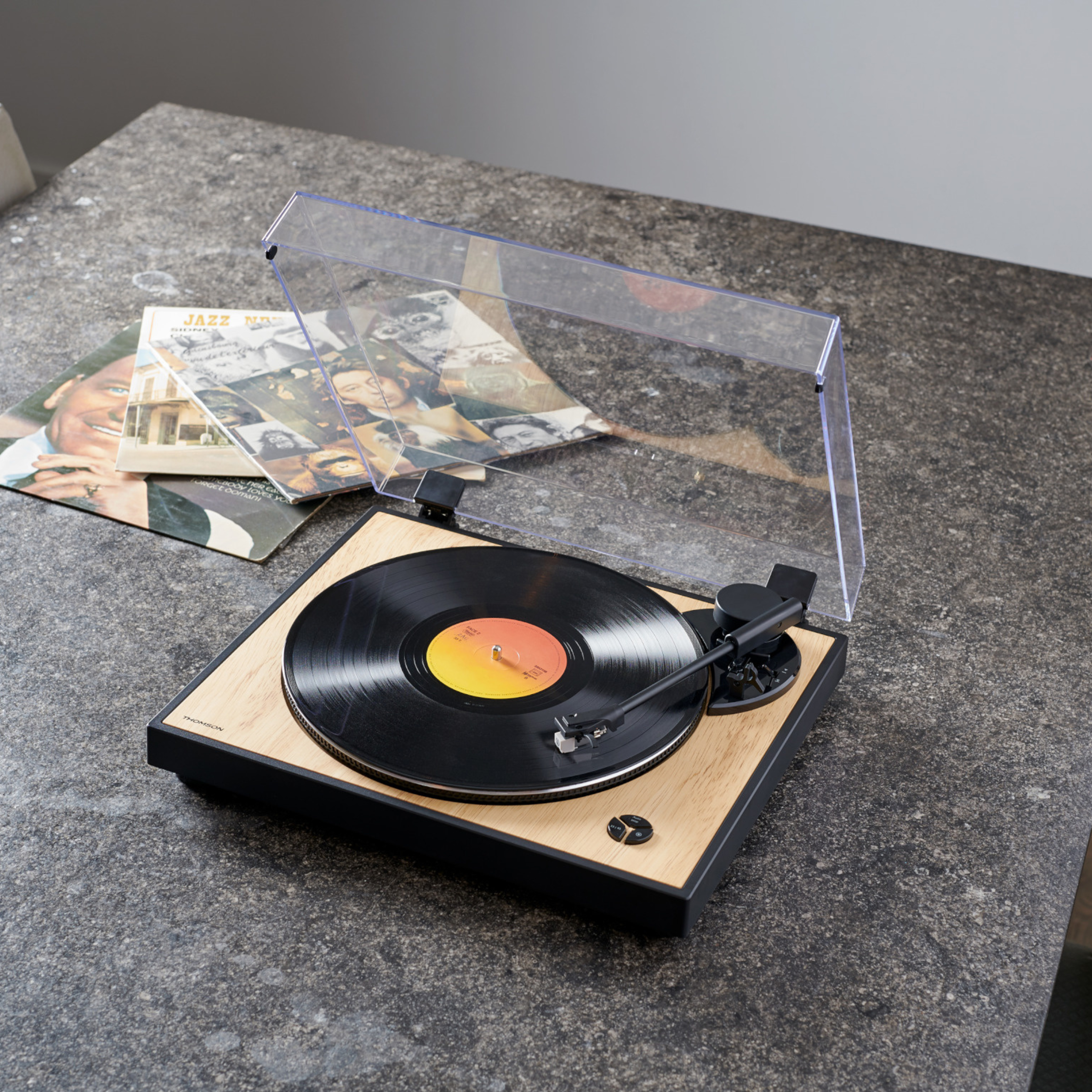 Gramofon z płytą grającą na szarej powierzchni.