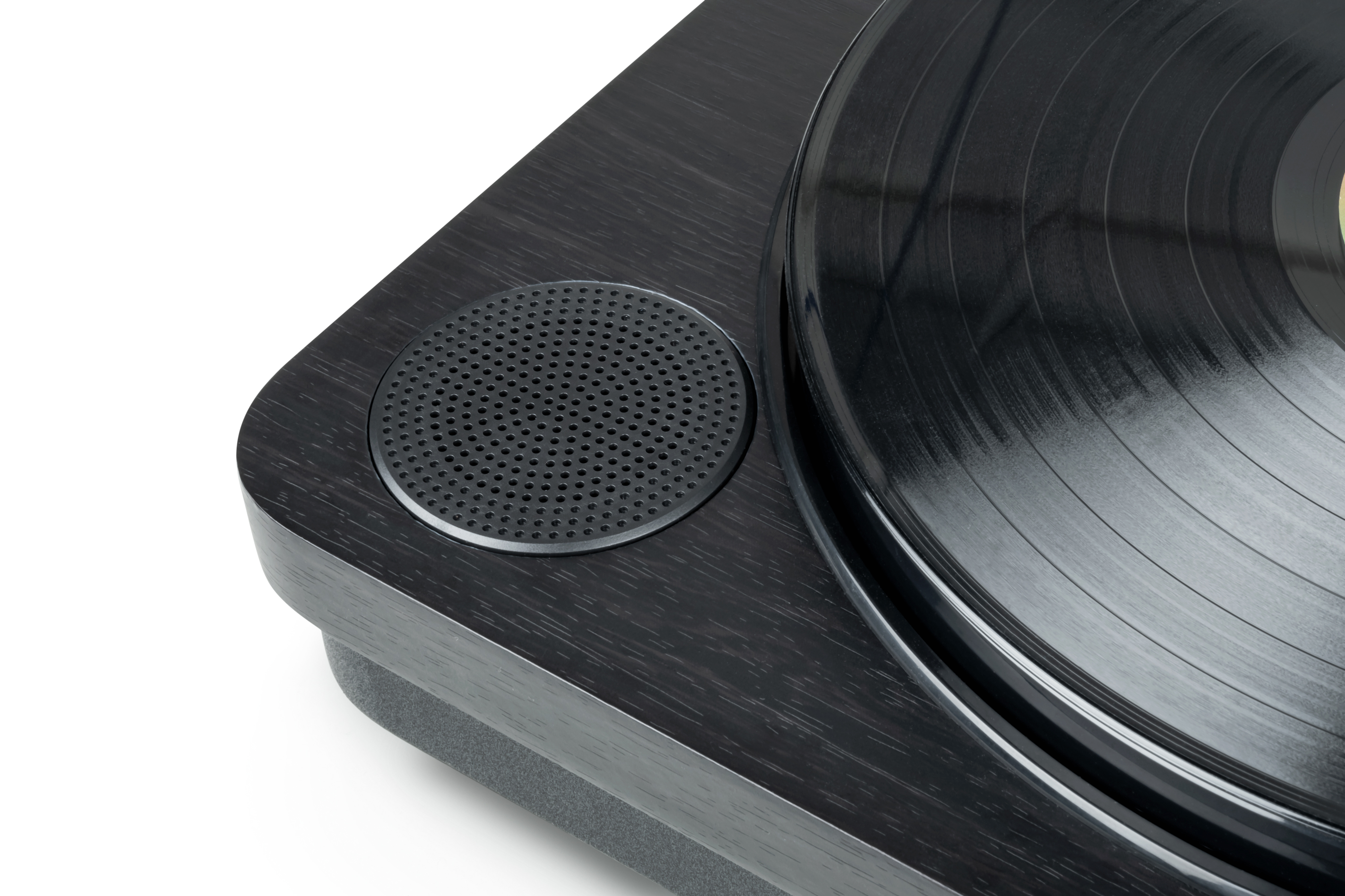 Zbliżenie głośnika gramofonu z czarną kratką i wykończeniem z ciemnego drewna.