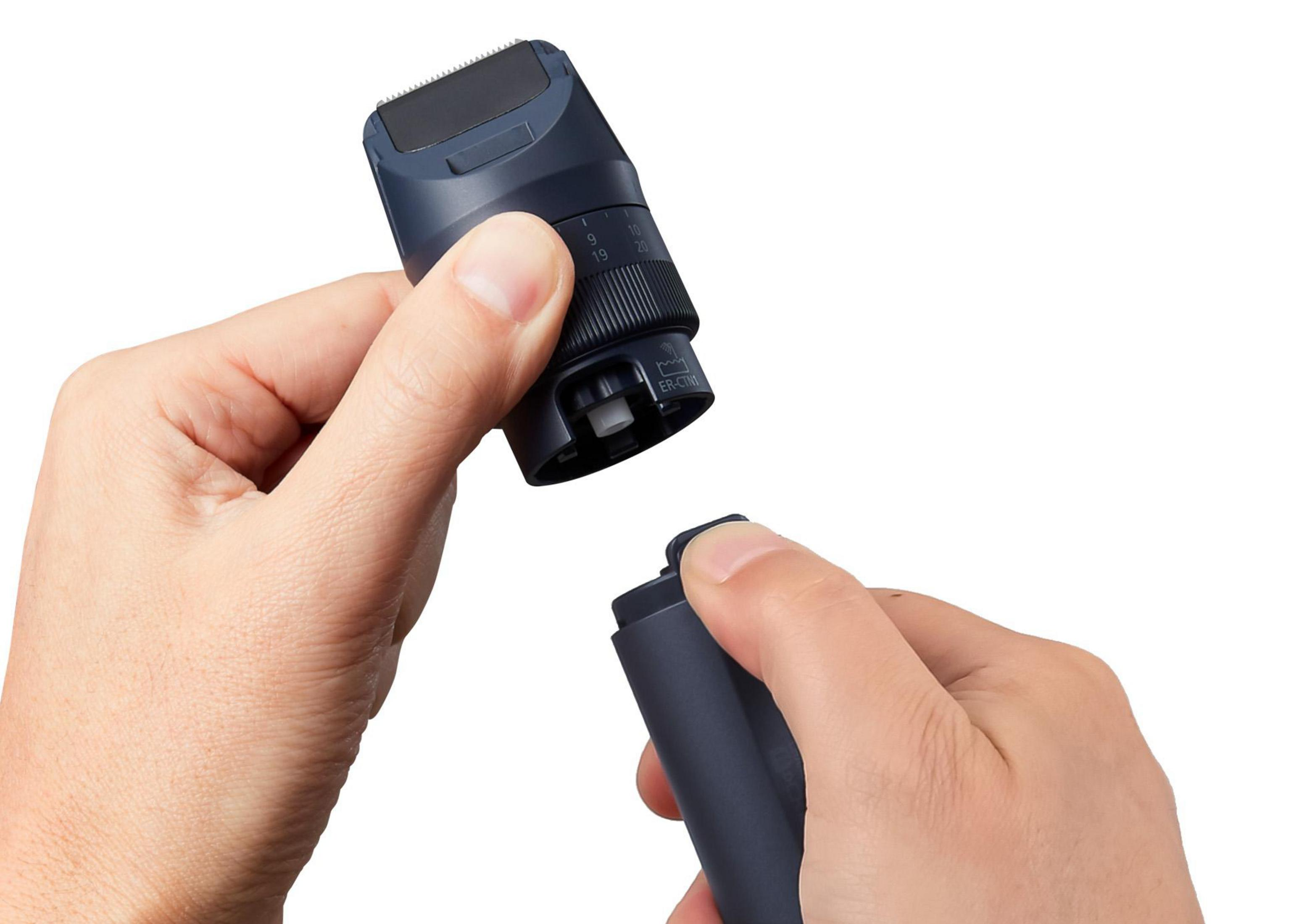 Dłonie trzymające i składające czarną głowicę golarki. Białe tło.