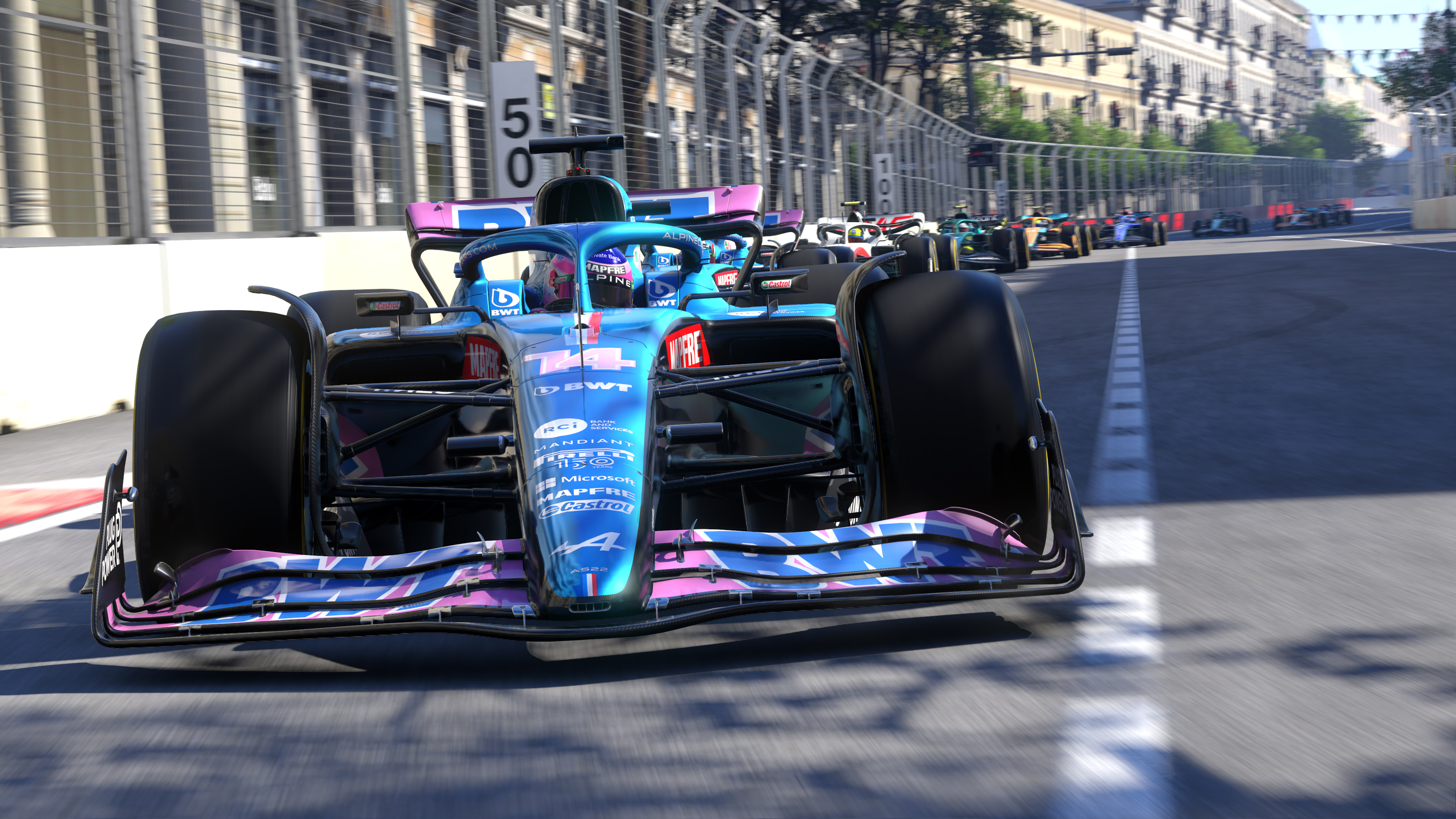 Auto da corsa di Formula 1 davanti, altre auto dietro. Corsa su una pista.