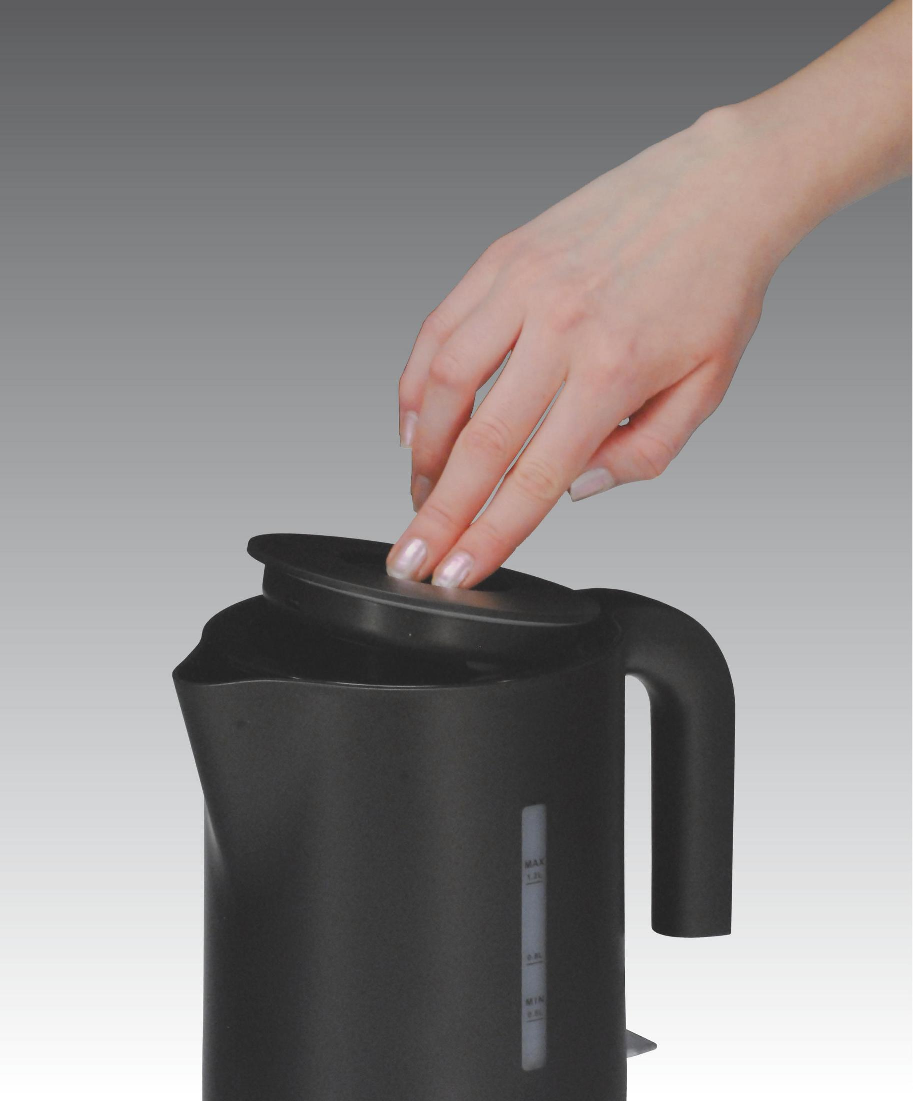 Hand öffnet den Deckel eines schwarzen Wasserkochers. Der Deckel ist schwarz und der Wasserkocher steht auf weißem Grund.