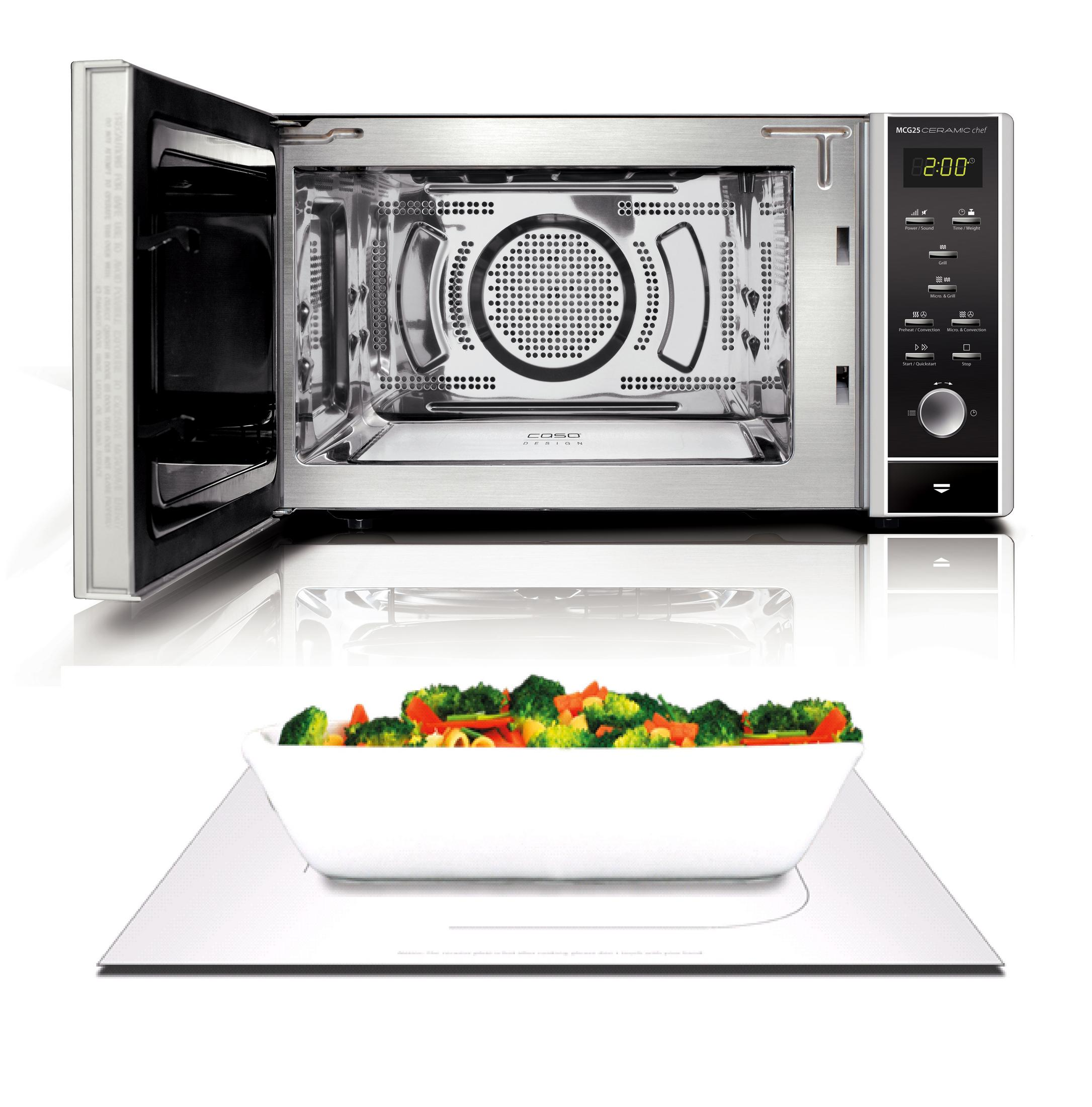 Forno a microonde con la porta aperta. Una ciotola di verdure cotte all'interno. Sfondo bianco.
