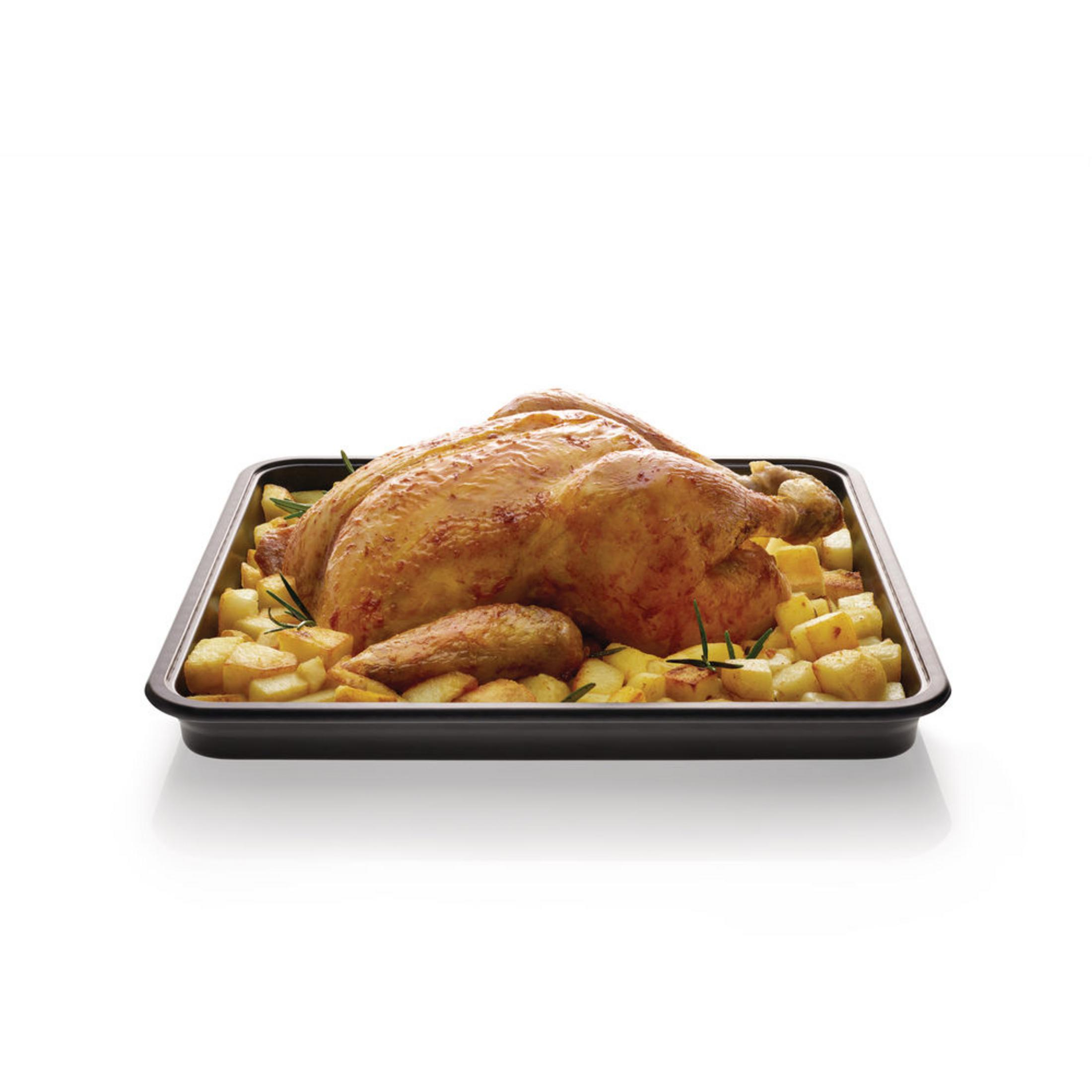 Gebratenes Hähnchen und Kartoffeln in einer schwarzen Backform auf weißem Grund.