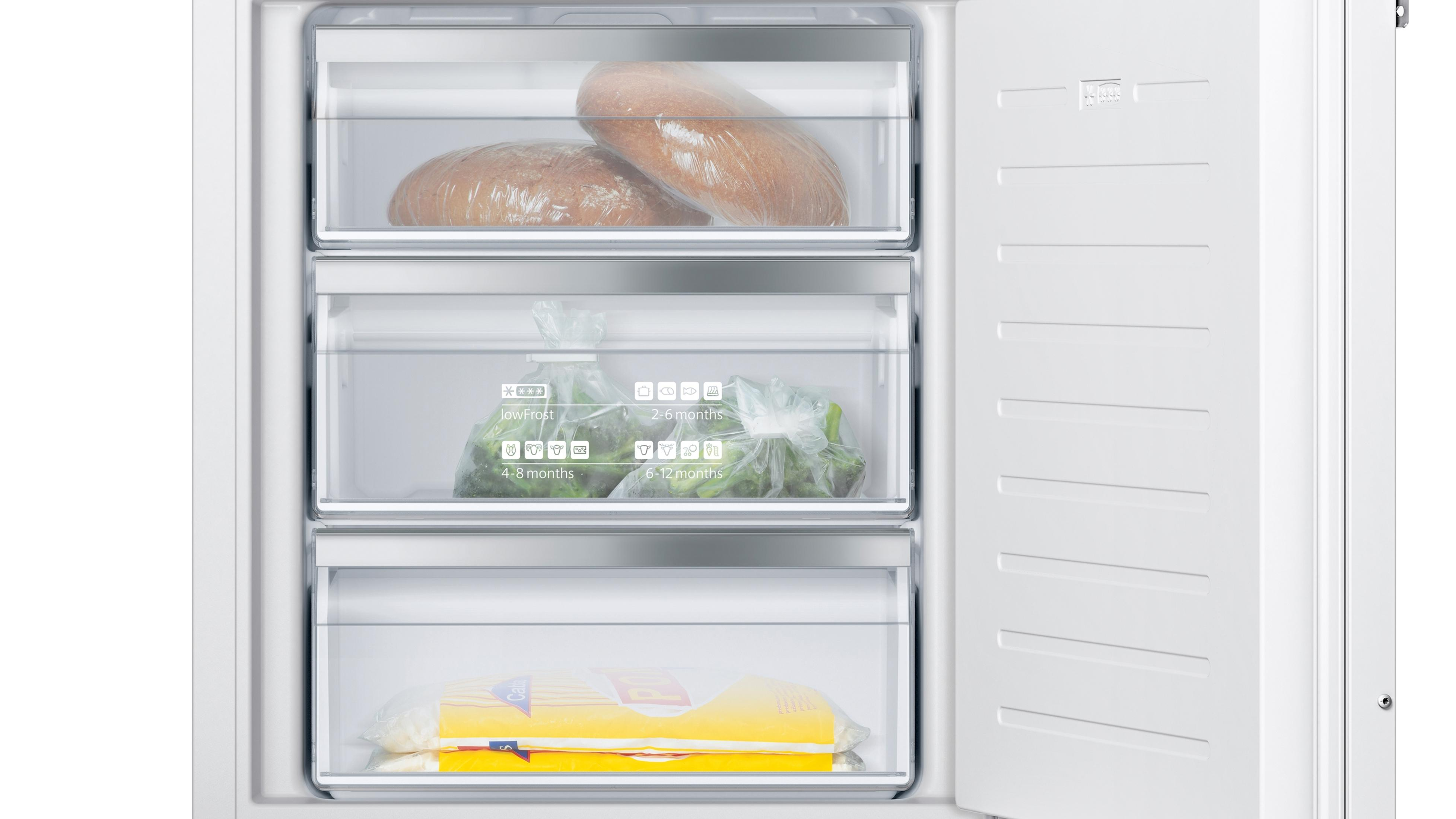 Offener Kühlschrank mit Schubladen, Brot und Gemüse.