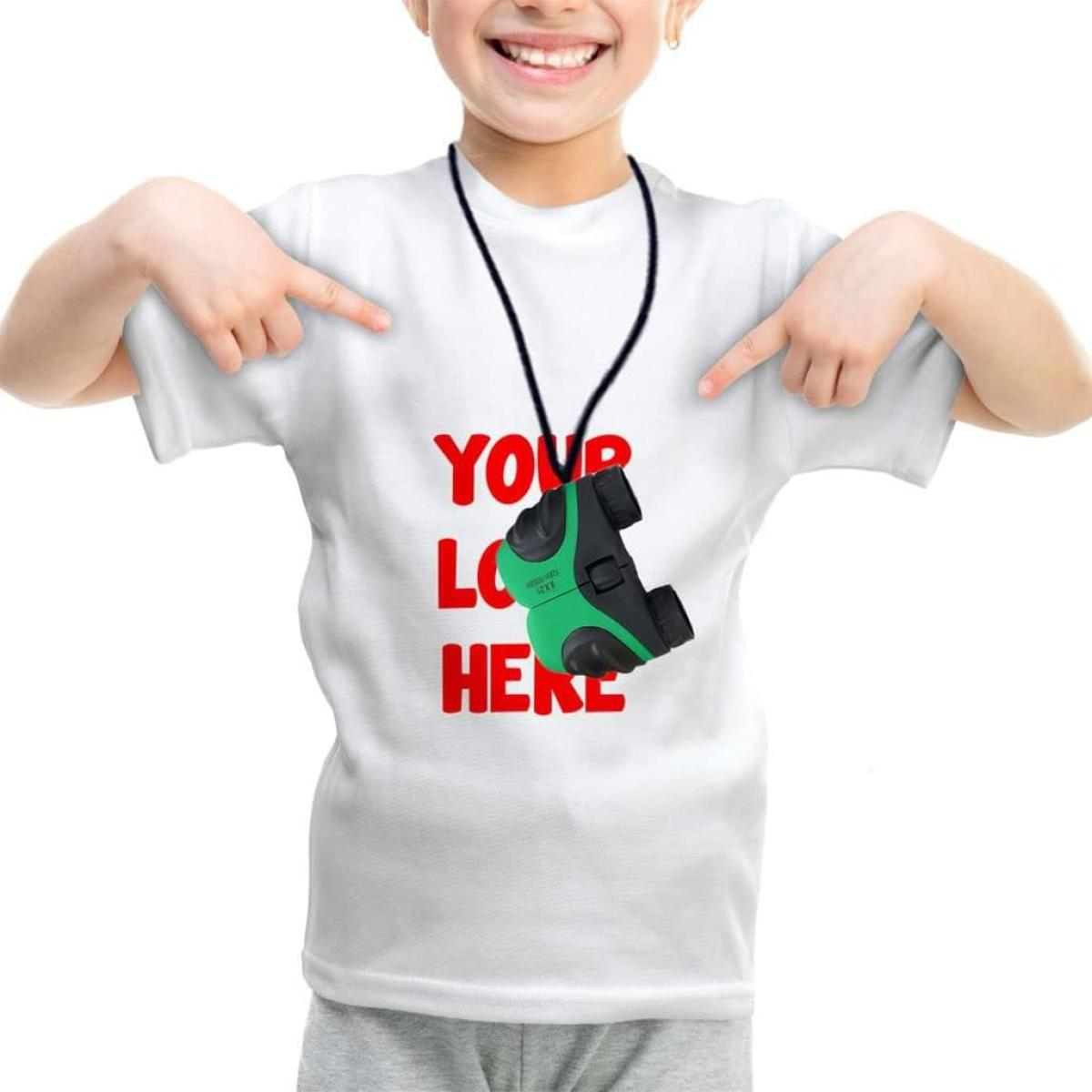 Ein Kind trägt ein weißes Hemd mit 'YOUR LOGO HERE' und zeigt auf ein grün-schwarzes Spielzeug.