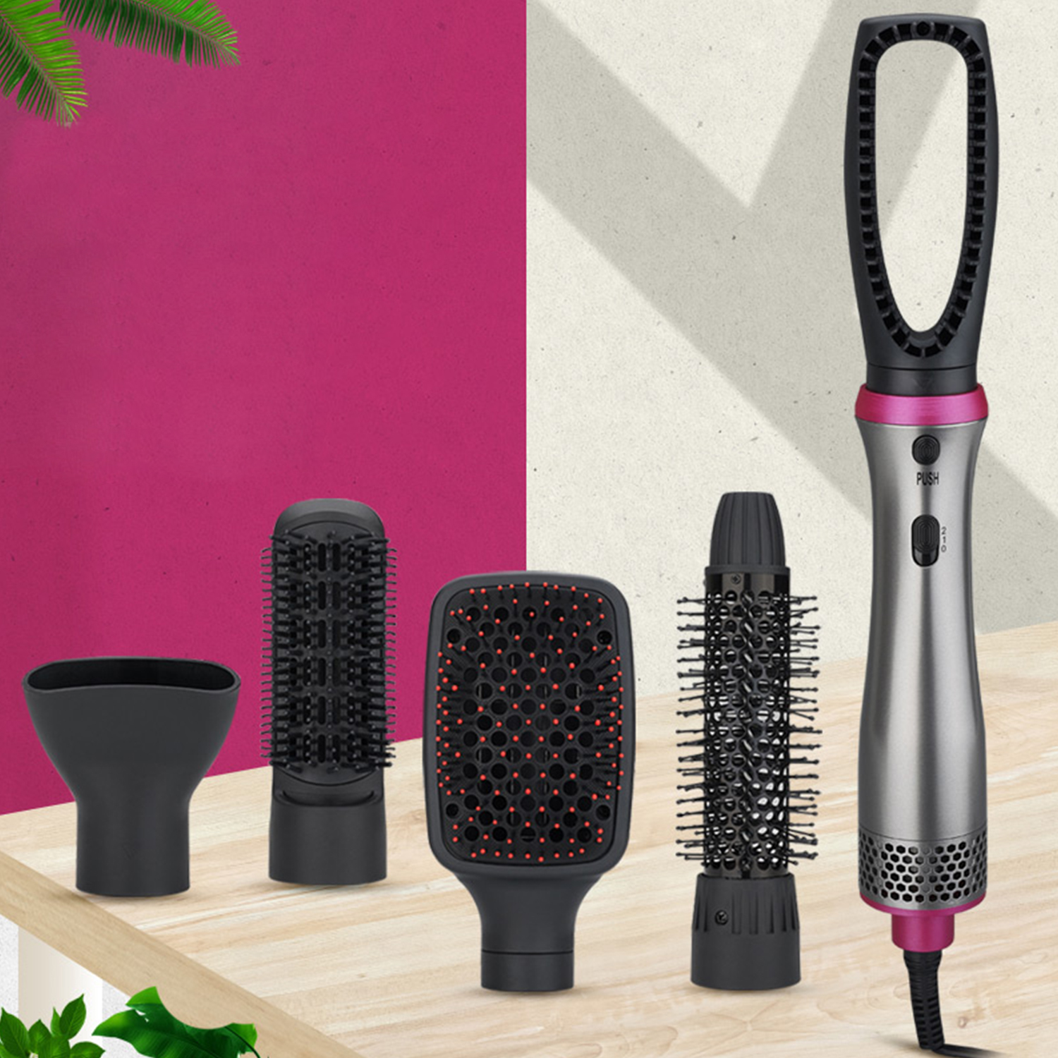 Set per lo styling dei capelli con asciugacapelli, diverse testine e sfondo rosa.