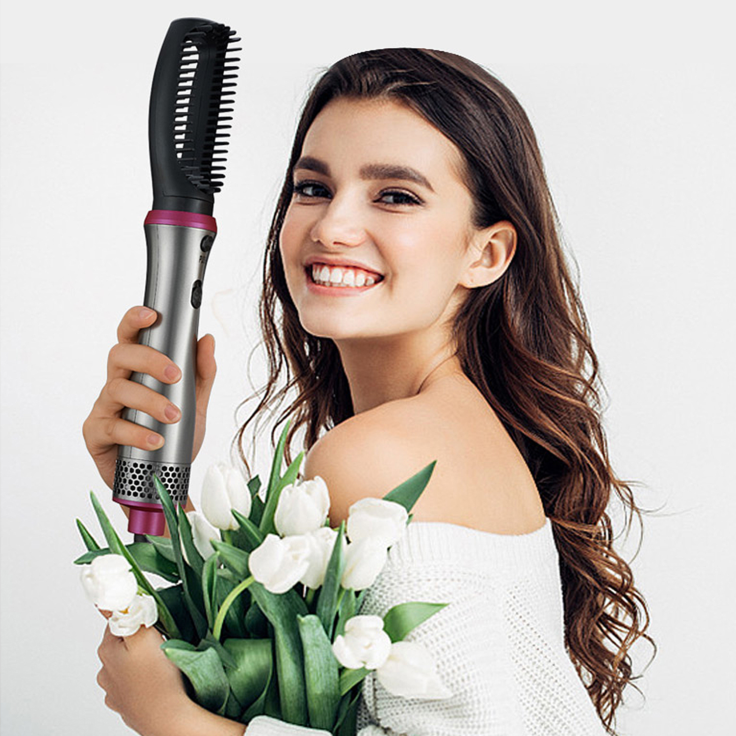 Una donna che tiene in mano uno strumento per lo styling dei capelli e dei fiori, sorridendo alla fotocamera.