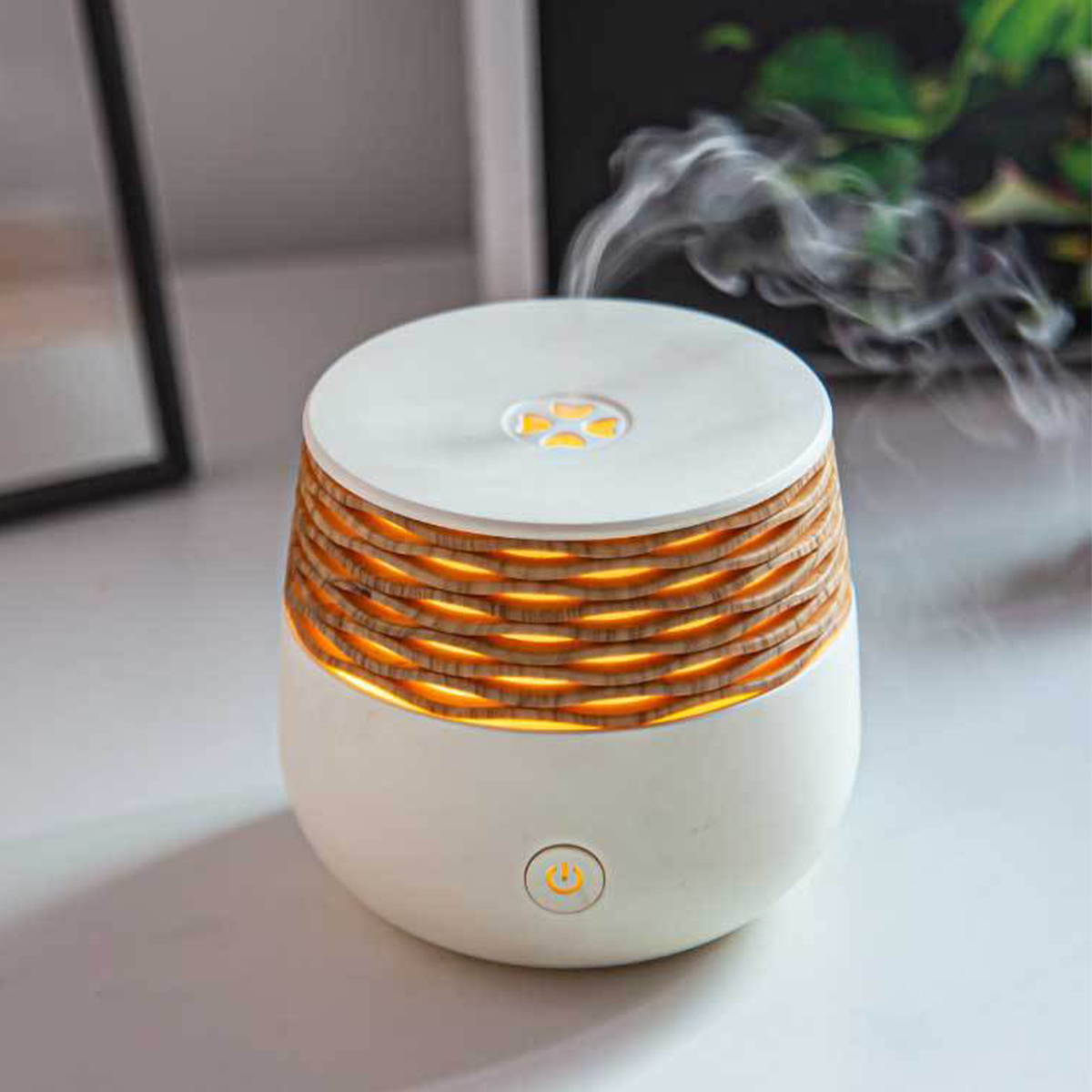Ein weiß-brauner Diffusor für ätherische Öle. Er gibt weißen Dampf ab. Der Diffusor hat einen Ein-Aus-Knopf.