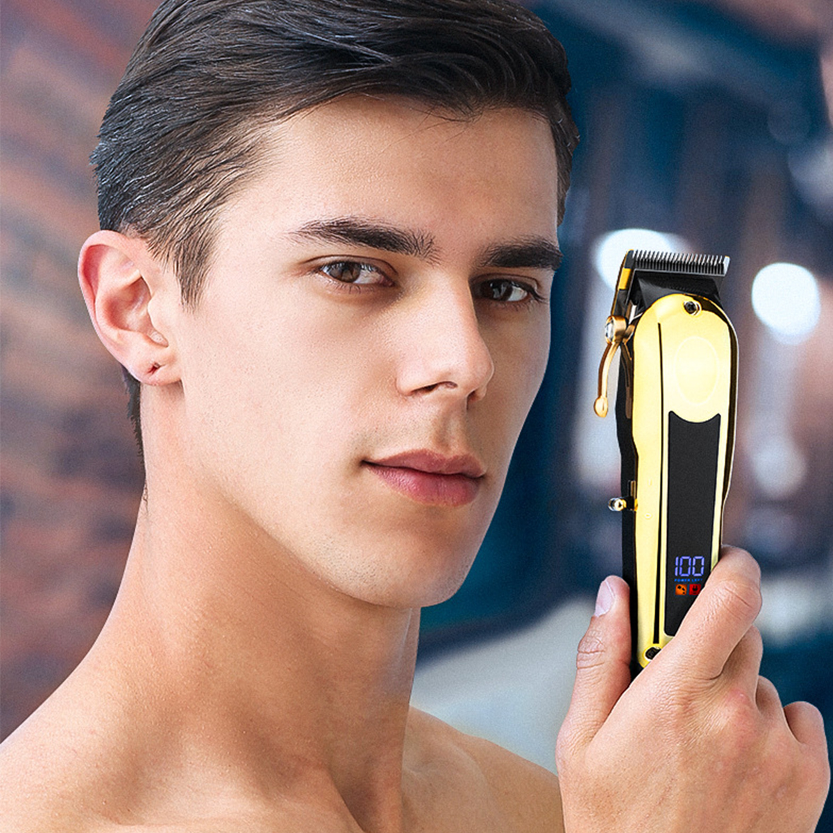 Ein Mann hält einen gold-schwarzen Haarschneider und blickt in die Kamera.