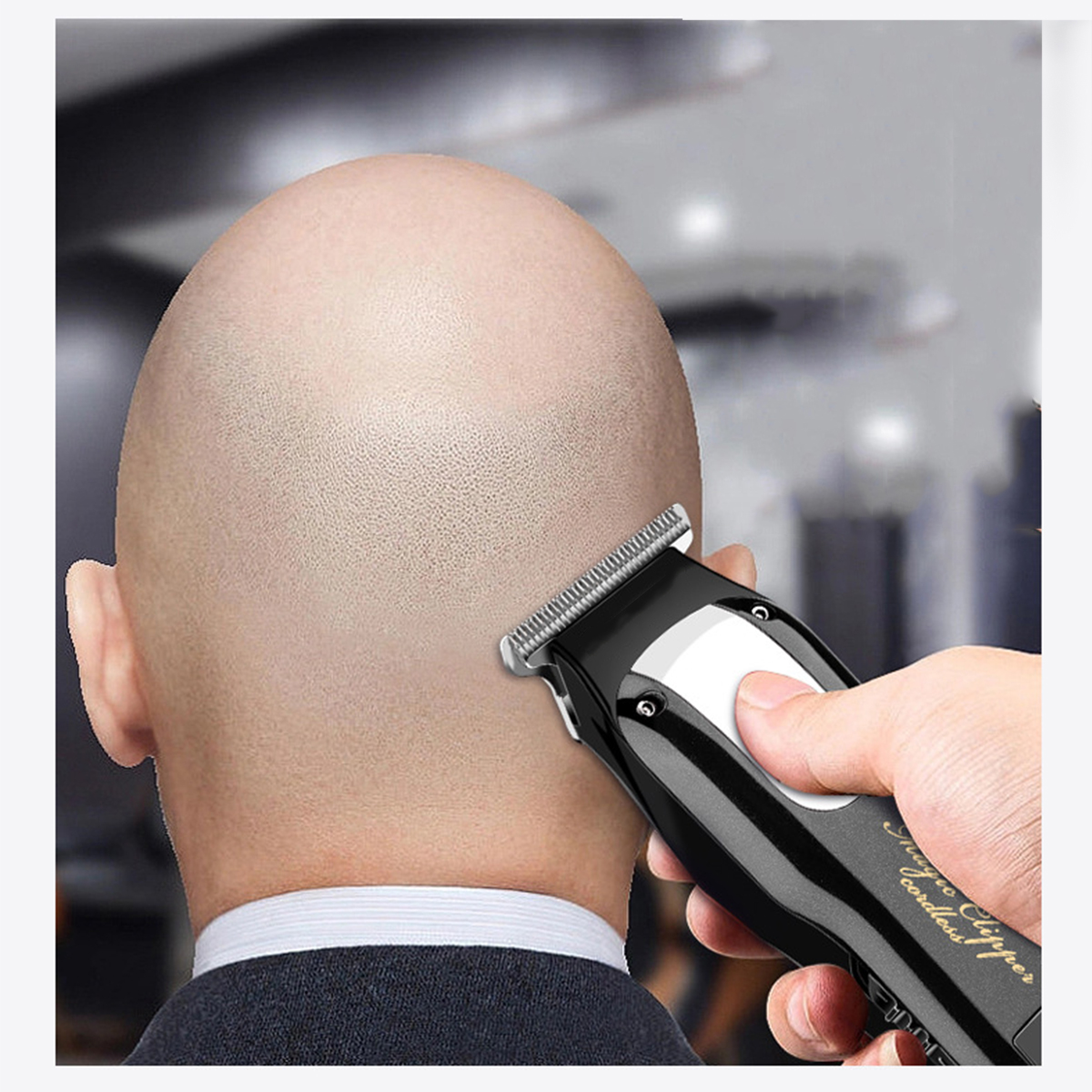 Eine Person benutzt einen schwarzen Haarschneider auf einem kahlen Kopf. Der Haarschneider ist kabellos.