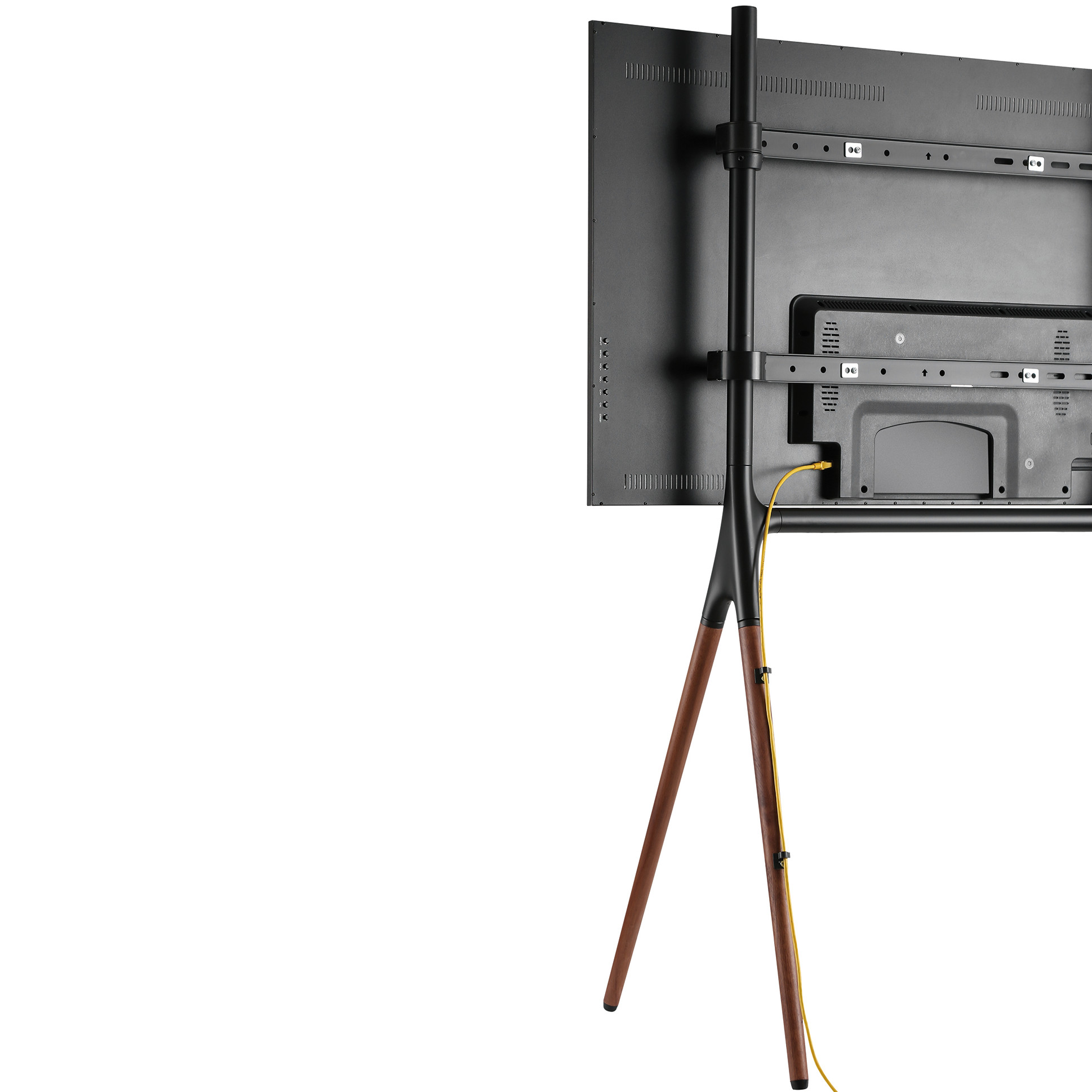 TV-Ständer, von hinten gesehen. Ein schwarzer Fernseher ist montiert. Der Ständer hat Holzbeine.
