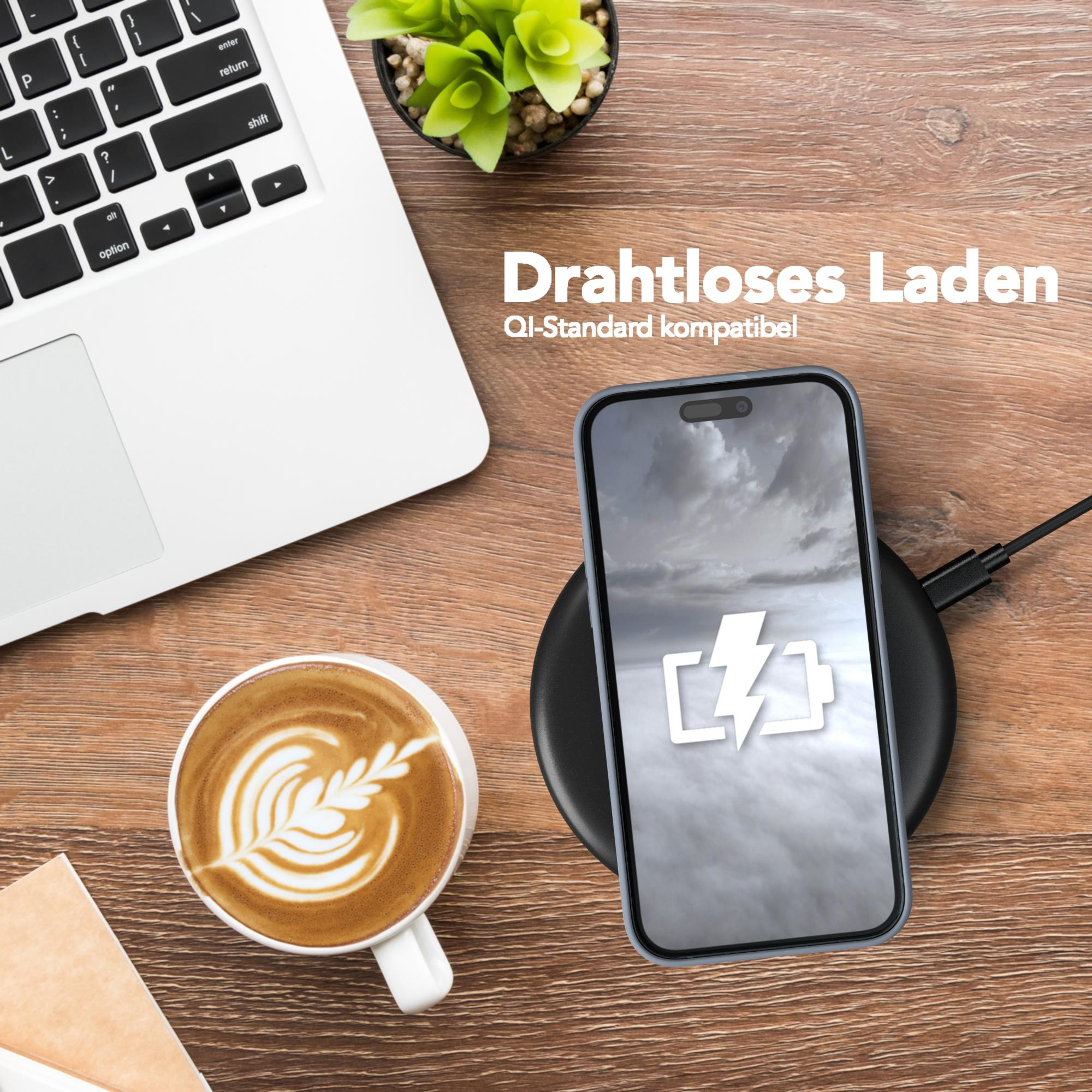 Telefon lädt auf einem Pad, neben Laptop und Kaffeetasse.