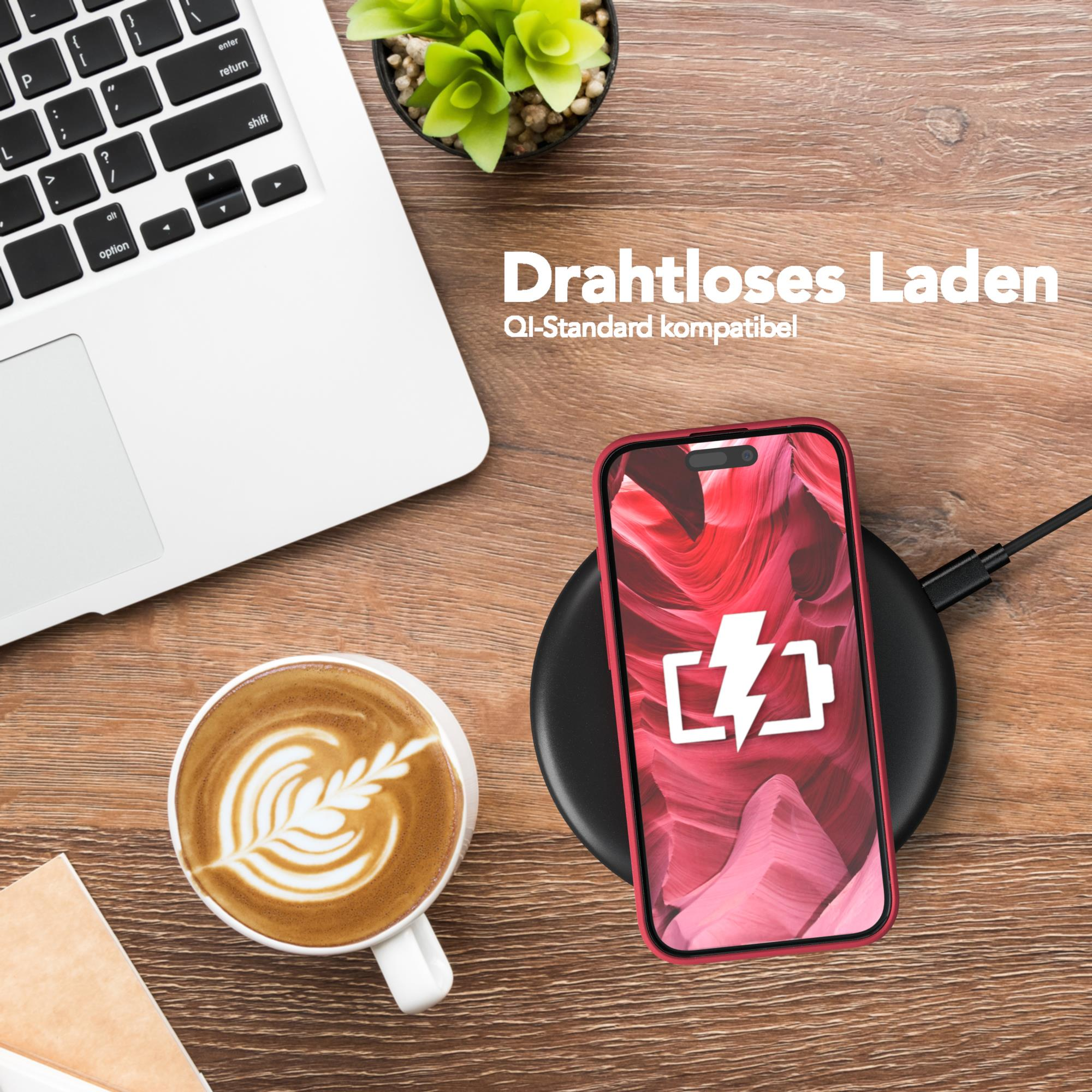 Ein Telefon, das drahtlos auf einem Ladepad geladen wird, mit Kaffee und Laptop in der Nähe.