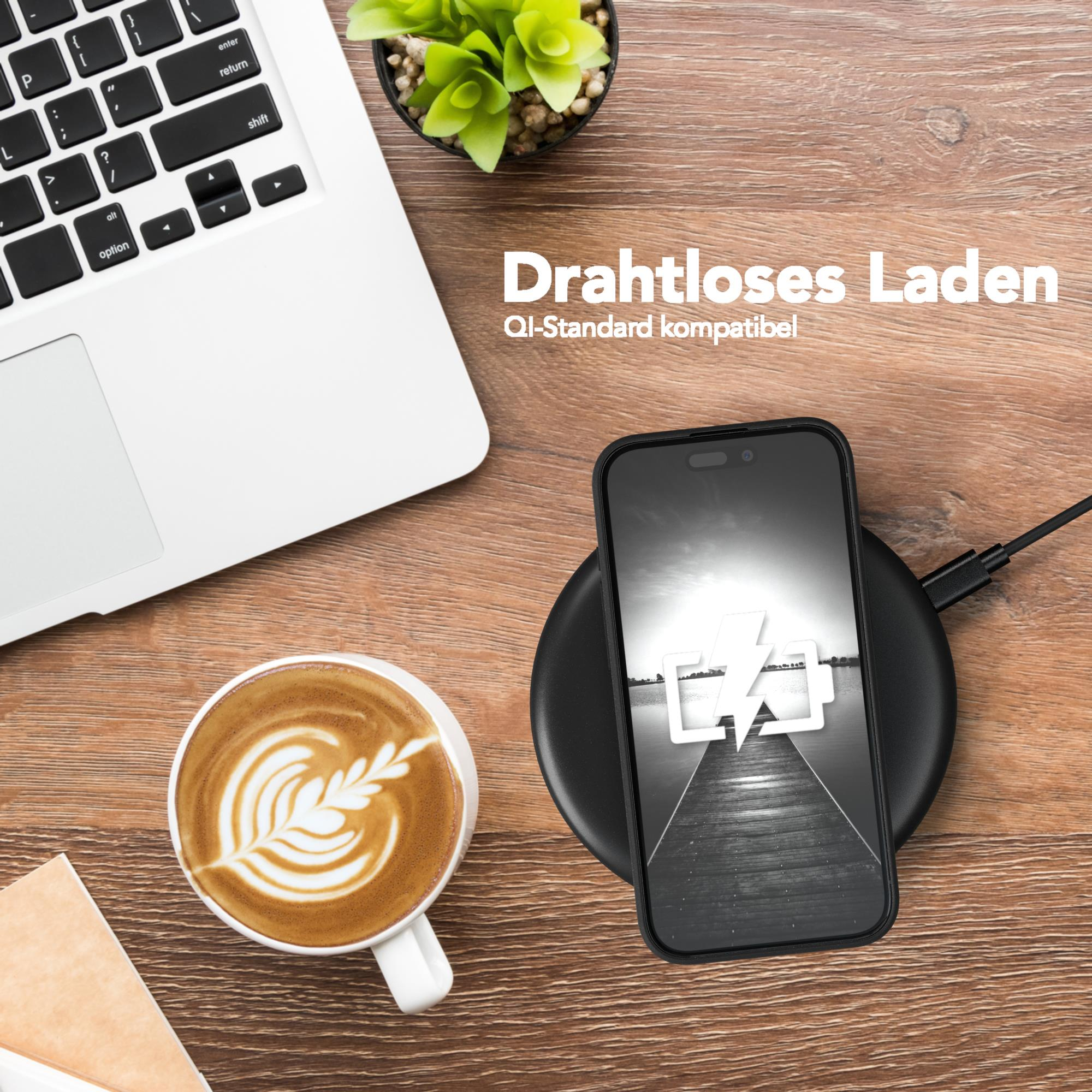 Telefon auf Ladepad neben einem Laptop und einer Kaffeetasse.