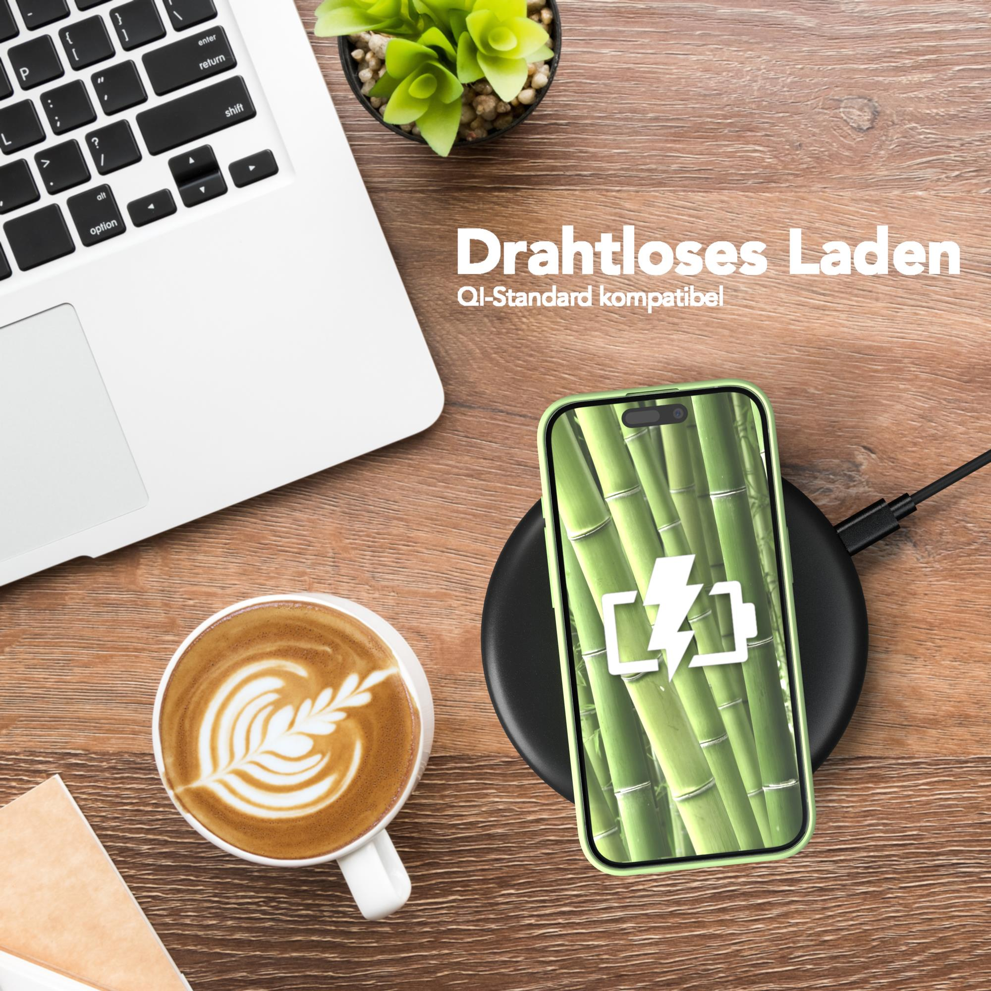 Draufsicht auf Laptop, Kaffeetasse und Telefon, das auf Holzoberfläche geladen wird.