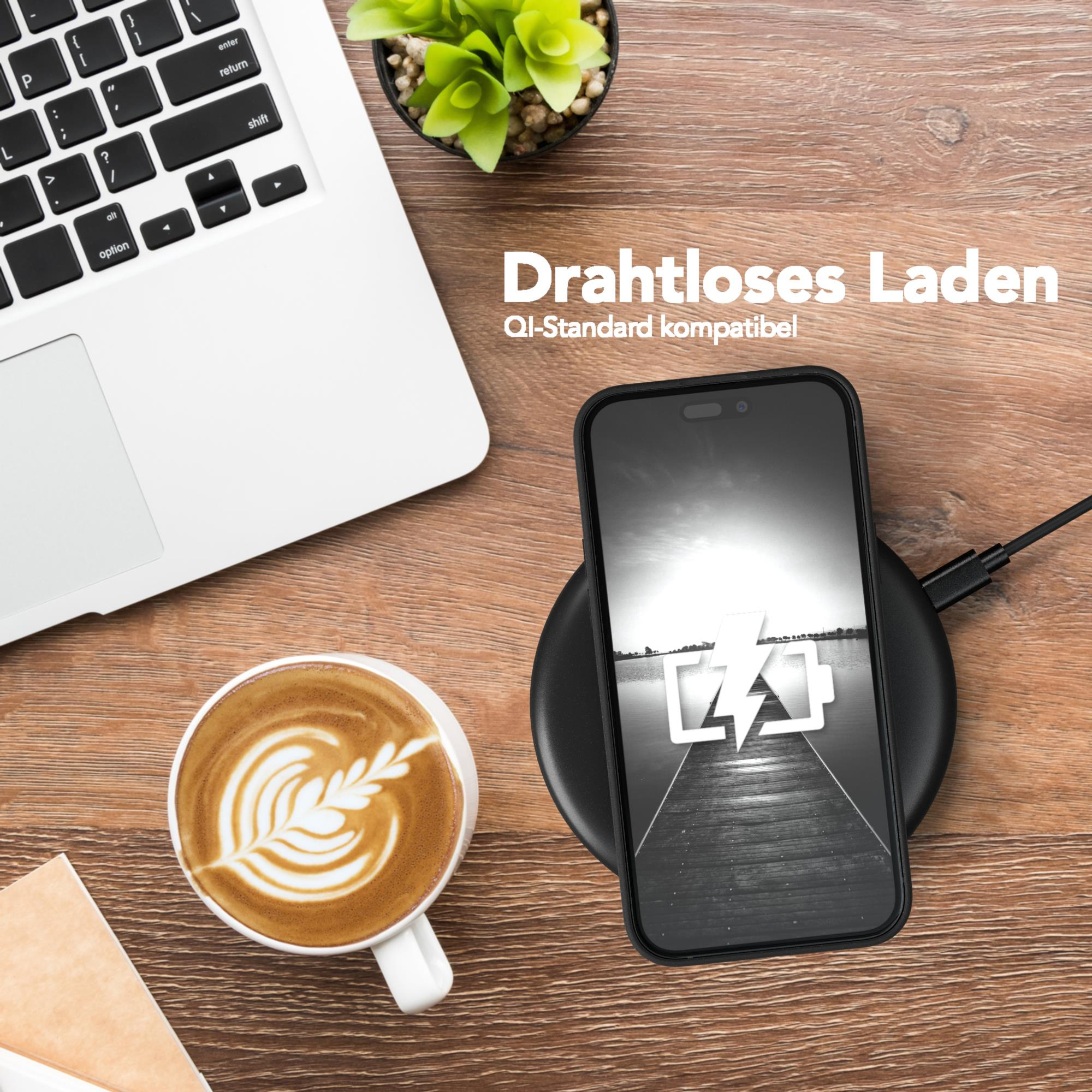 Telefon wird drahtlos auf einem schwarzen Pad geladen. Kaffeetasse und Laptop daneben. Holztisch. Weißer Hintergrund.