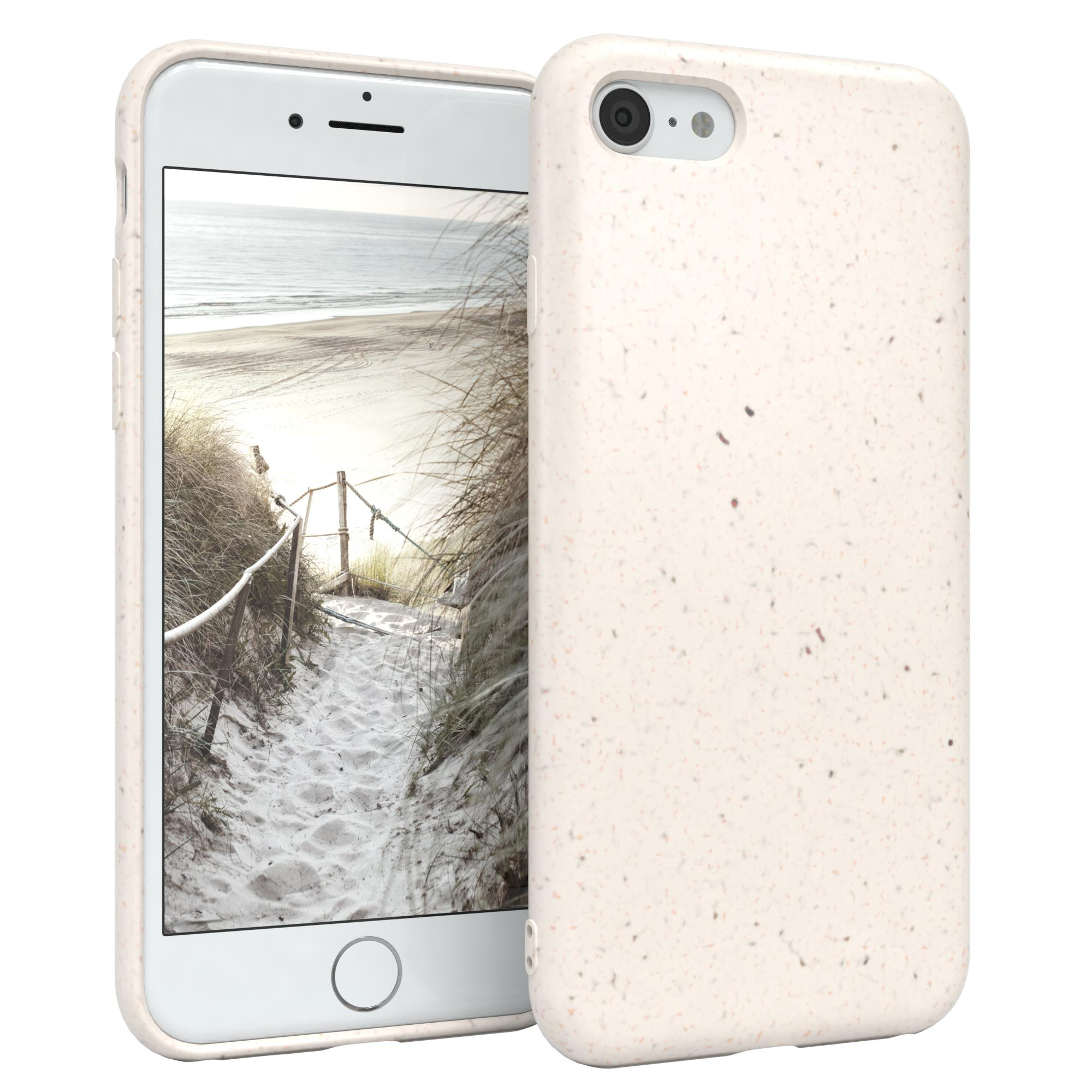 Weißes iPhone in einem beigefarbenen Gehäuse. Das Gehäuse hat eine gesprenkelte Textur. Der Hintergrund ist eine Strandszene.