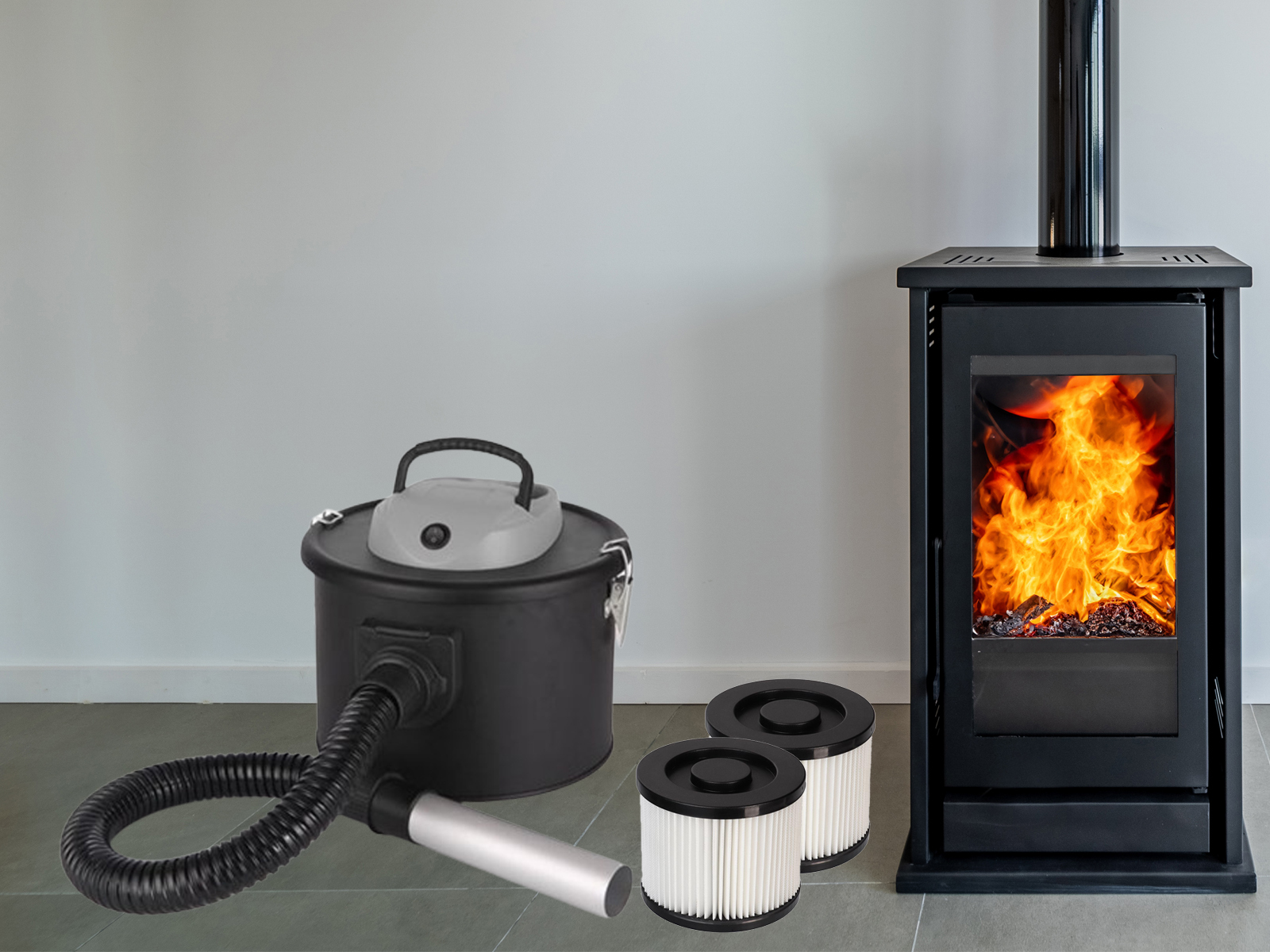 Ein schwarzer Staubsauger mit Schlauch und zwei Filtern neben einem beleuchteten schwarzen Kamin. Die Wand ist hellgrau.