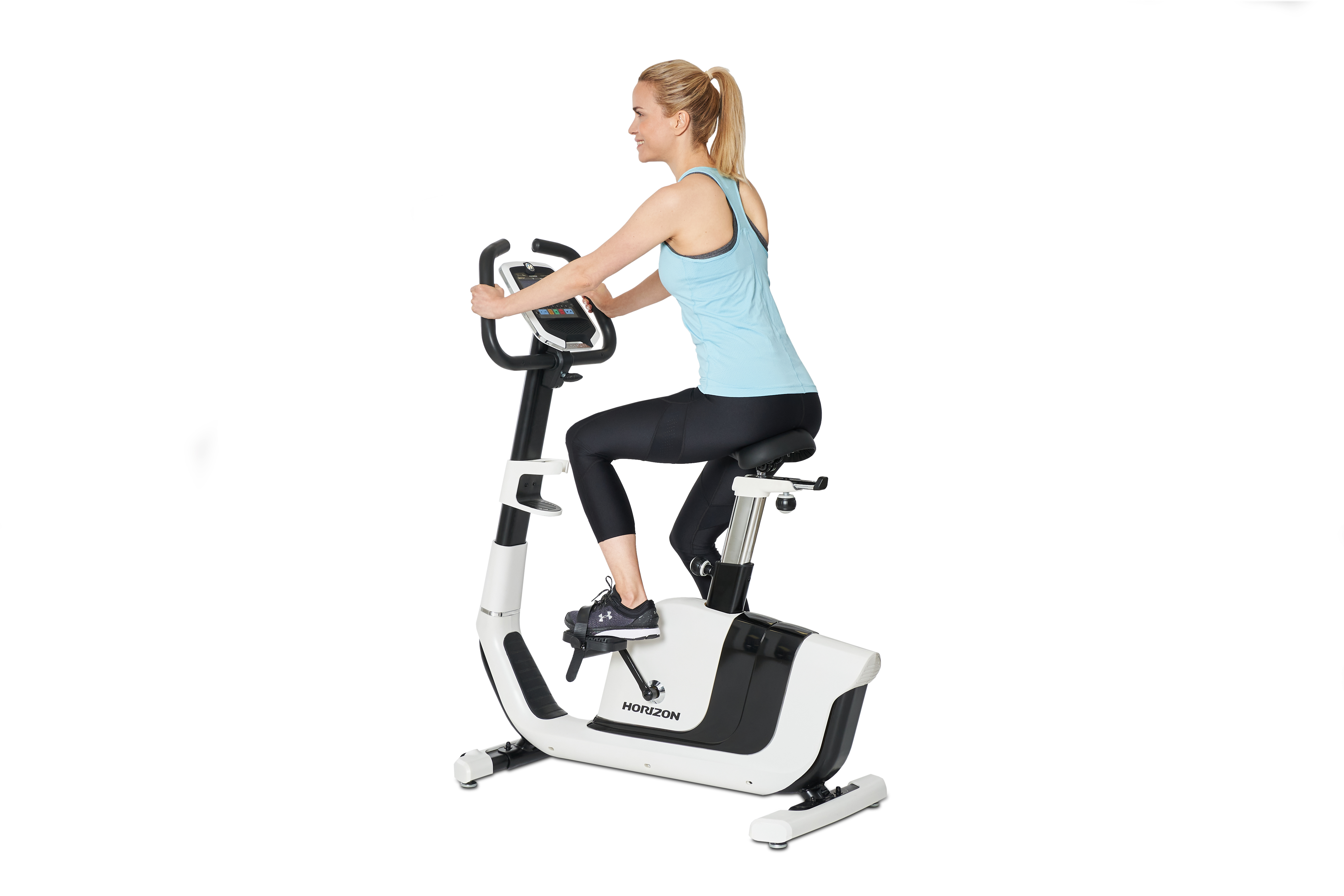 Kobieta ćwicząca na biało-czarnym rowerze stacjonarnym, z białym tłem.