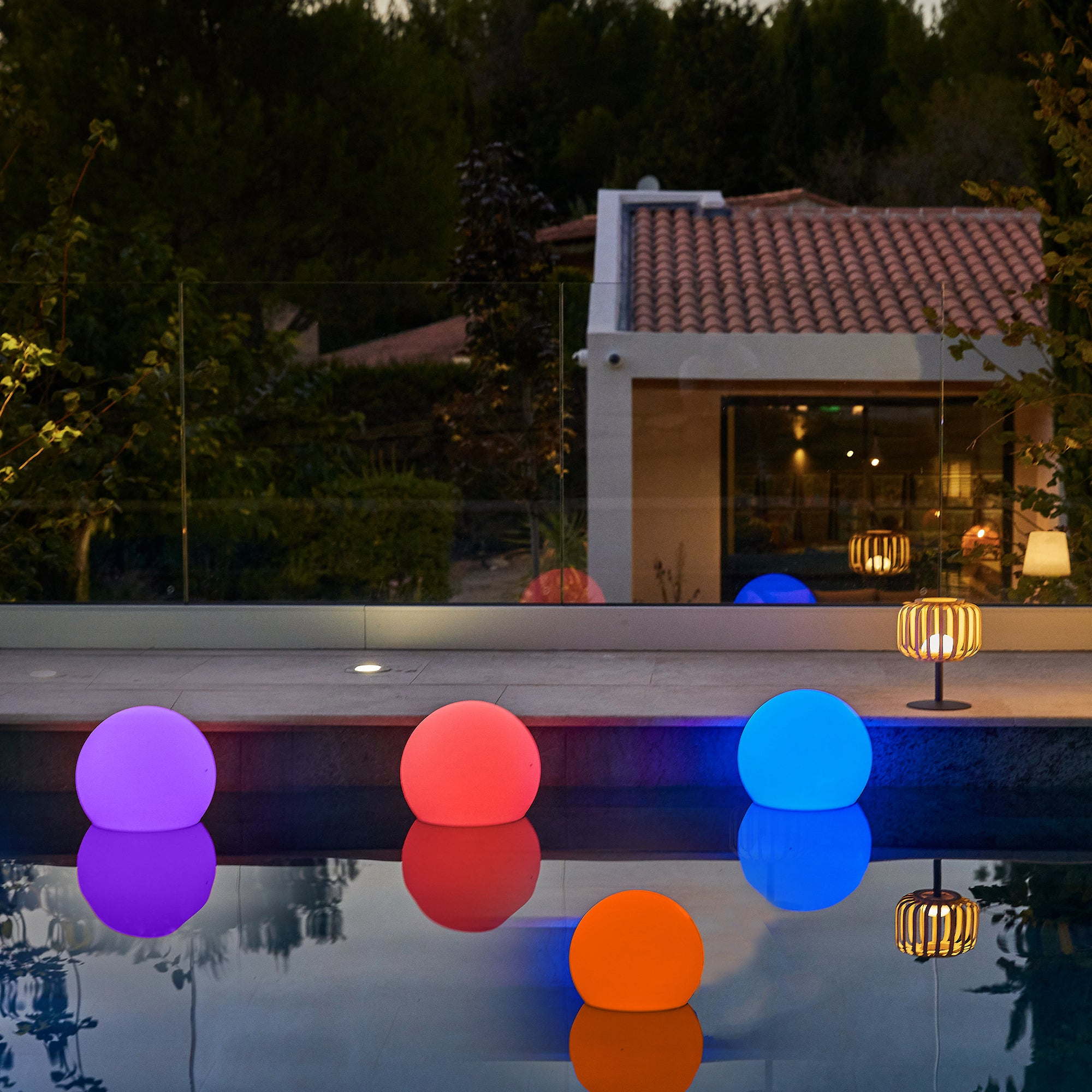 Leuchtende Kugeln in einem Pool bei Nacht.