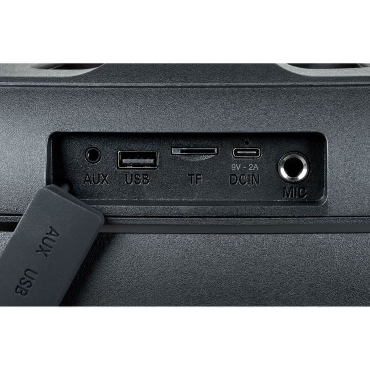 Tylny panel czarnego głośnika. Posiada różne porty oznaczone AUX, USB, TF, DCIN i MIC.