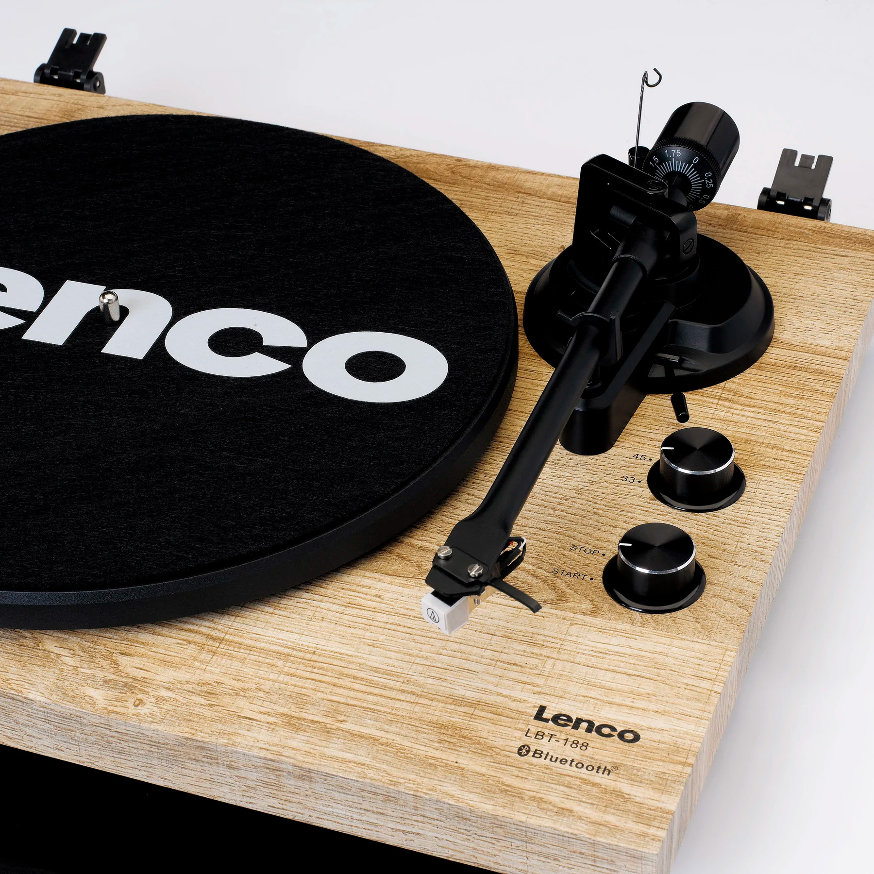 Gramofon z czarną płytą, ramieniem i drewnianą obudową.