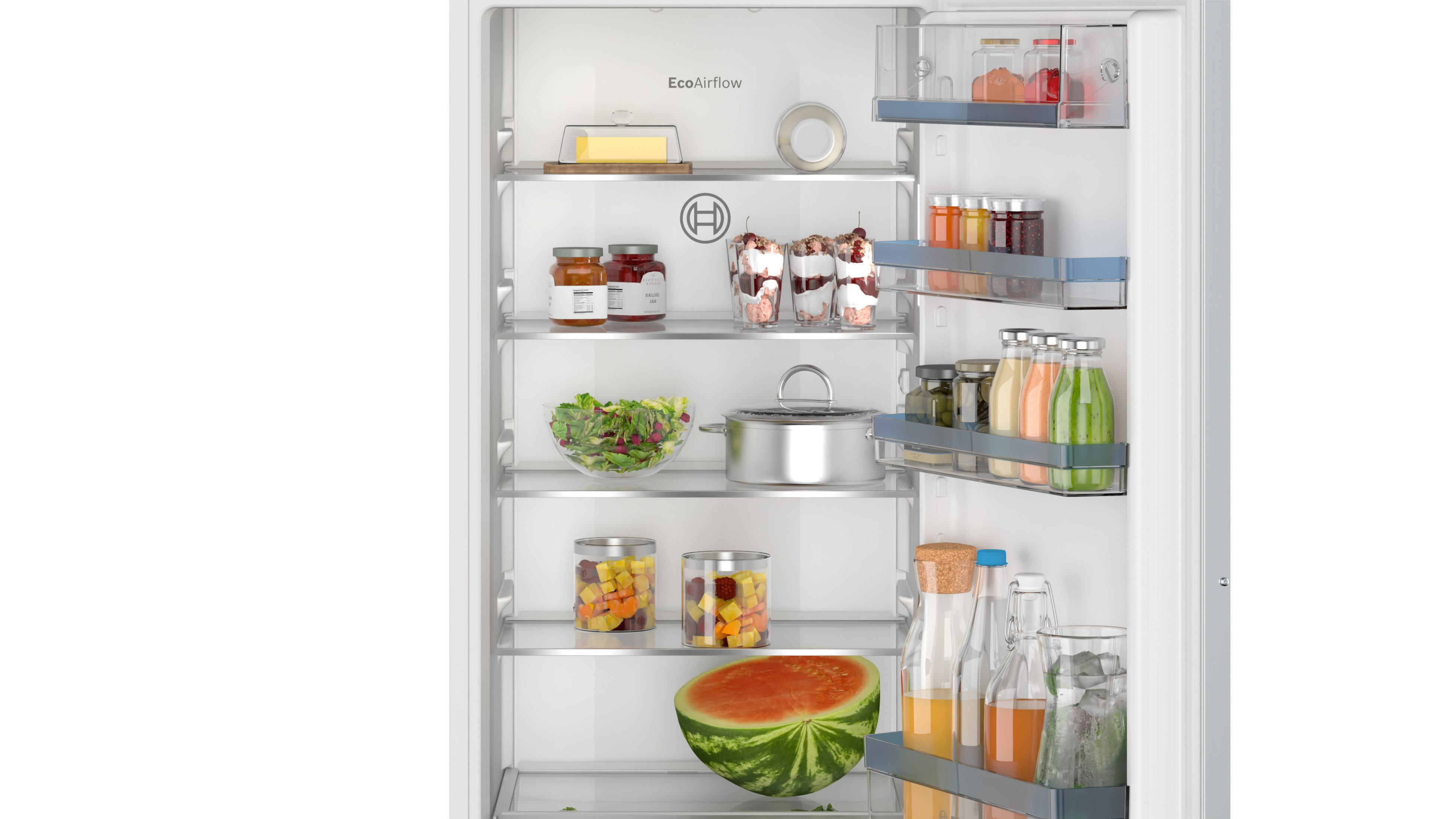 Offener Kühlschrank. Im Inneren befinden sich Regale mit Lebensmitteln wie Salaten, Früchten und Marmeladengläsern.