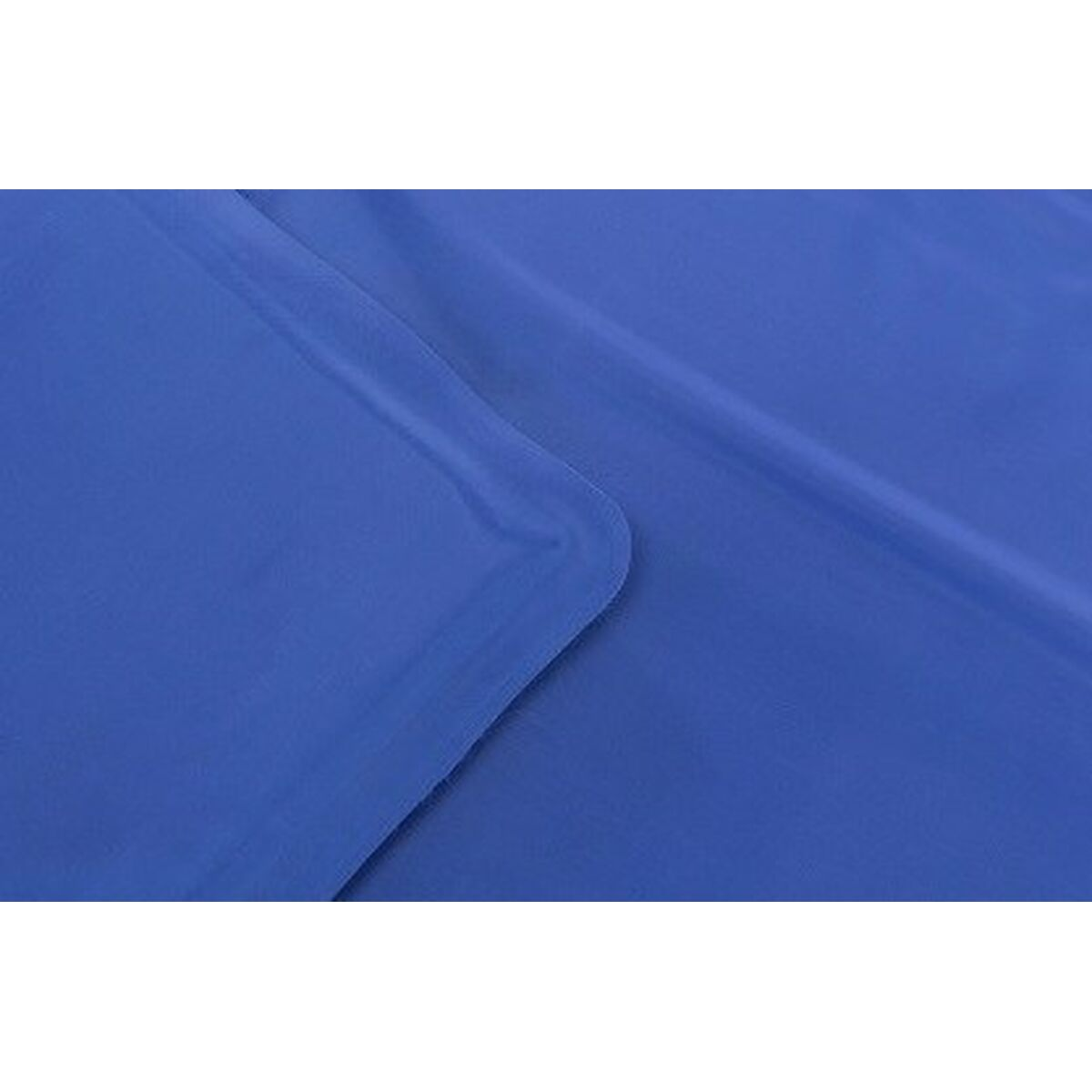Primo piano di un lenzuolo o tessuto blu, con una leggera piega nell'angolo.