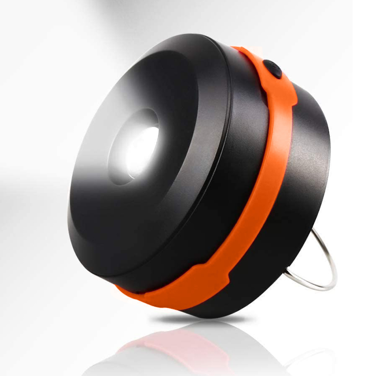 Schwarz-orange Campinglaterne, mit hellem Licht aus der Mitte.
