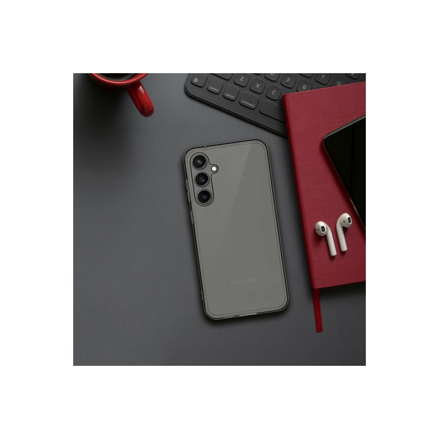 Uno smartphone in una custodia, un taccuino rosso, auricolari wireless e una tastiera sono su una superficie nera.
