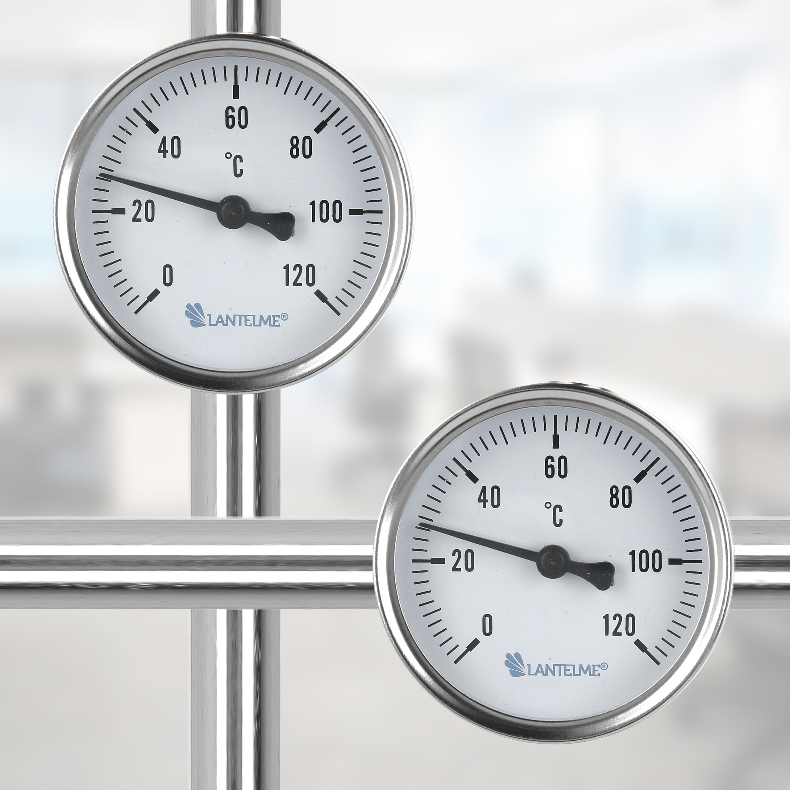 Zwei runde Thermometer, weißes Zifferblatt, schwarze Zahlen, auf weißem Hintergrund.