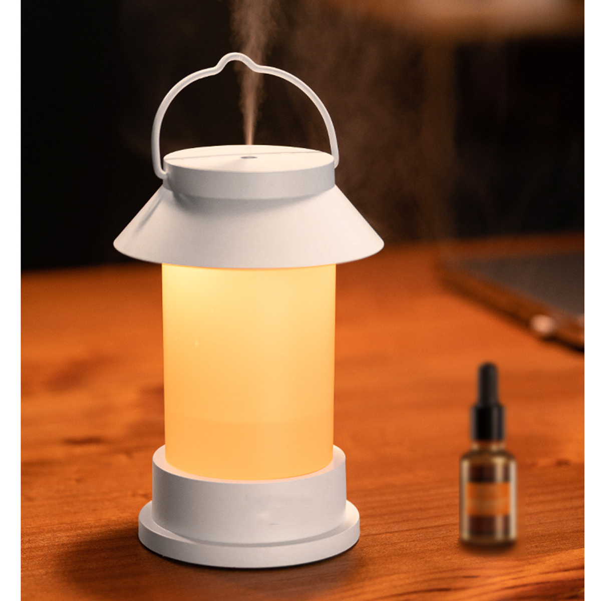 Weißer, laternenförmiger Diffusor für ätherische Öle mit Griff und Ölflasche daneben.
