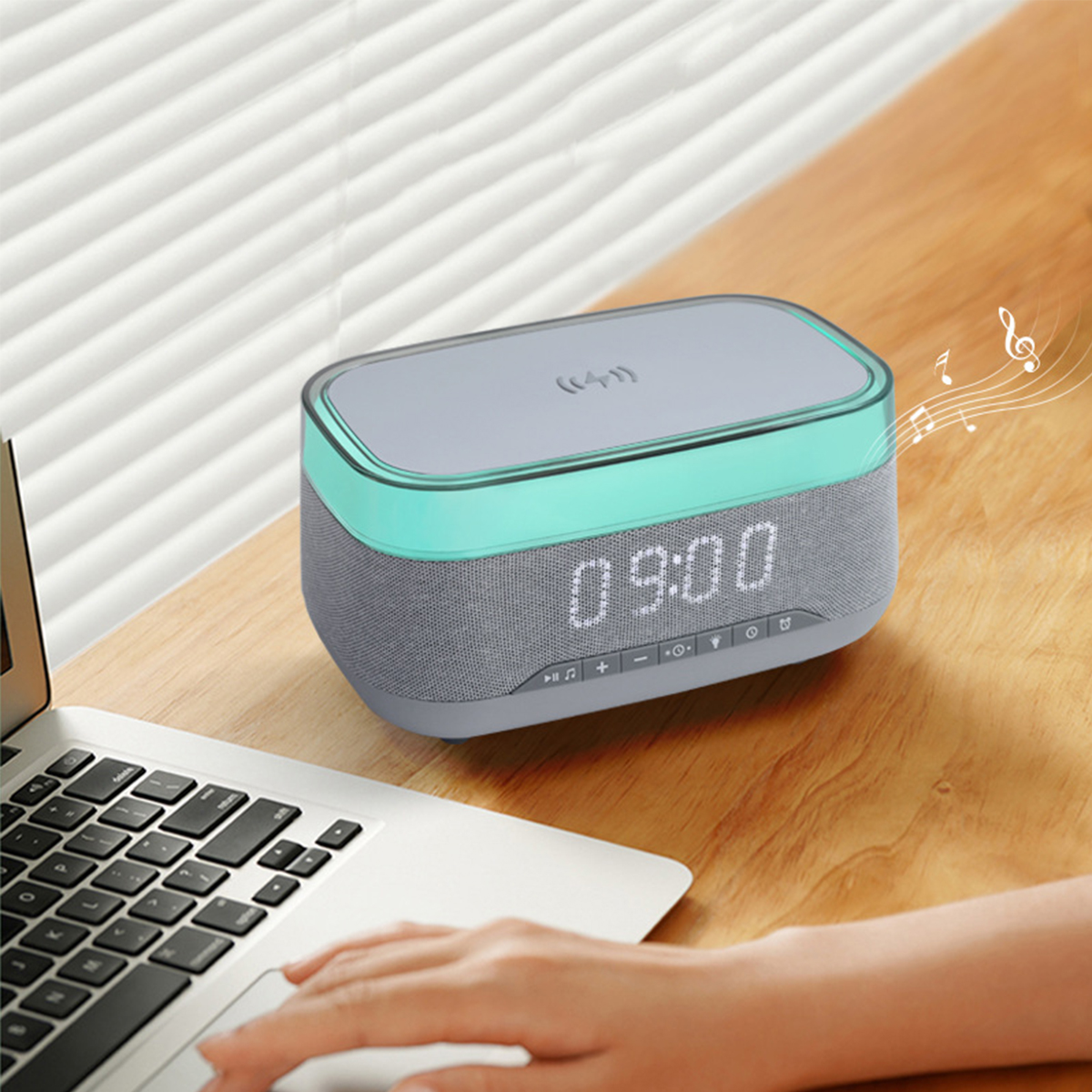 Grauer und tealfarbener Lautsprecher mit Digitaluhr, die 09:00 anzeigt, auf einem Holztisch.