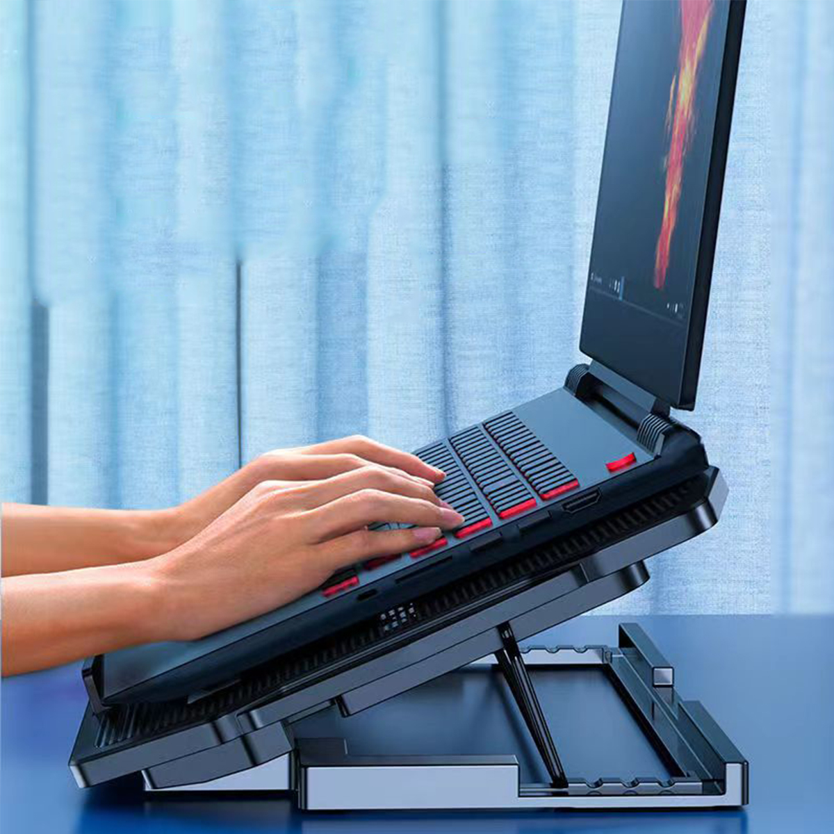 Ein Laptop auf einem schwarzen Laptop-Ständer, mit Händen, die auf der Tastatur tippen.