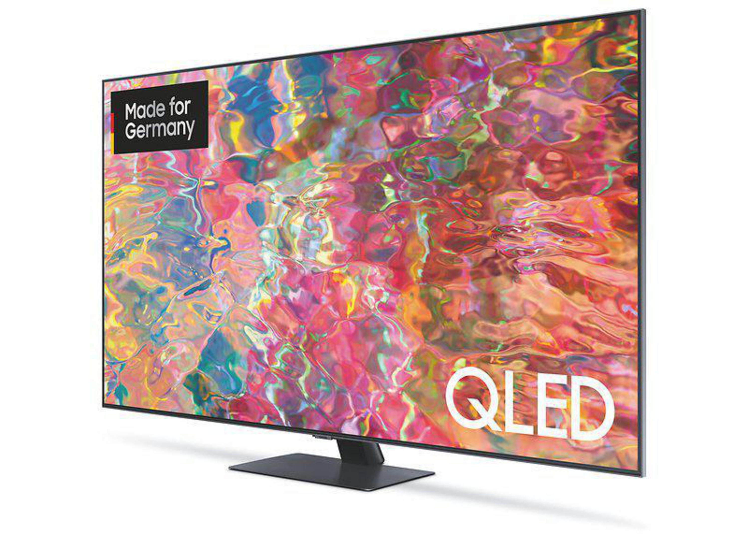 Ein großer QLED-Fernseher mit farbenfroher Anzeige, schwarzem Ständer und weißem Hintergrund.