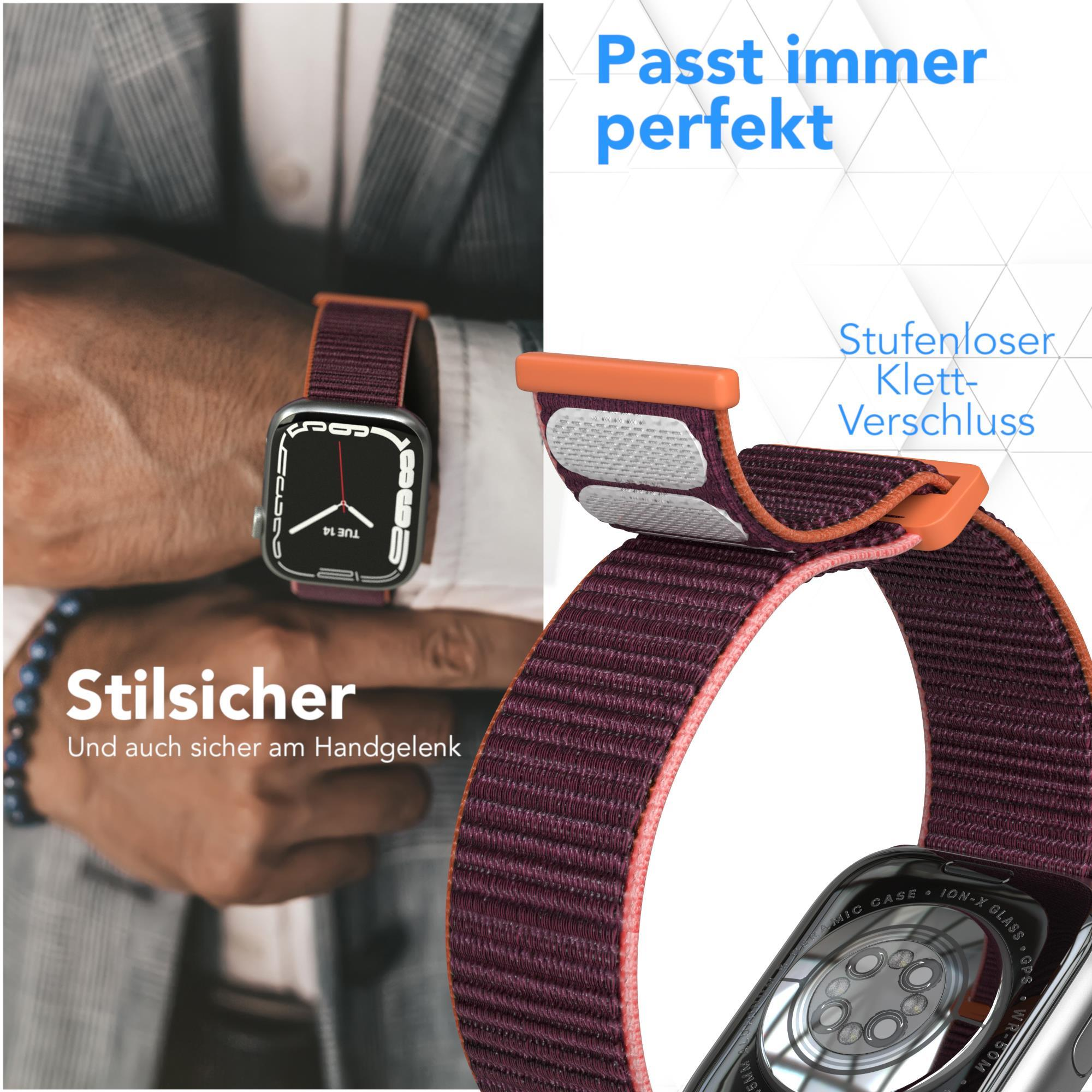Nahaufnahme einer Smartwatch mit weinrotem Armband. Das Armband hat einen Klettverschluss.