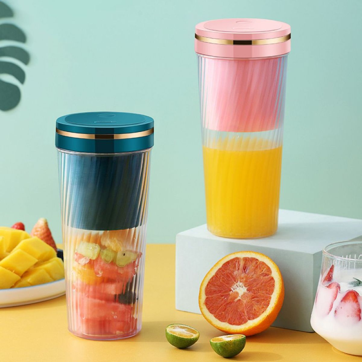 Zwei Mixer mit Saft. Einer hat rosa, der andere teal und grüne Farben.