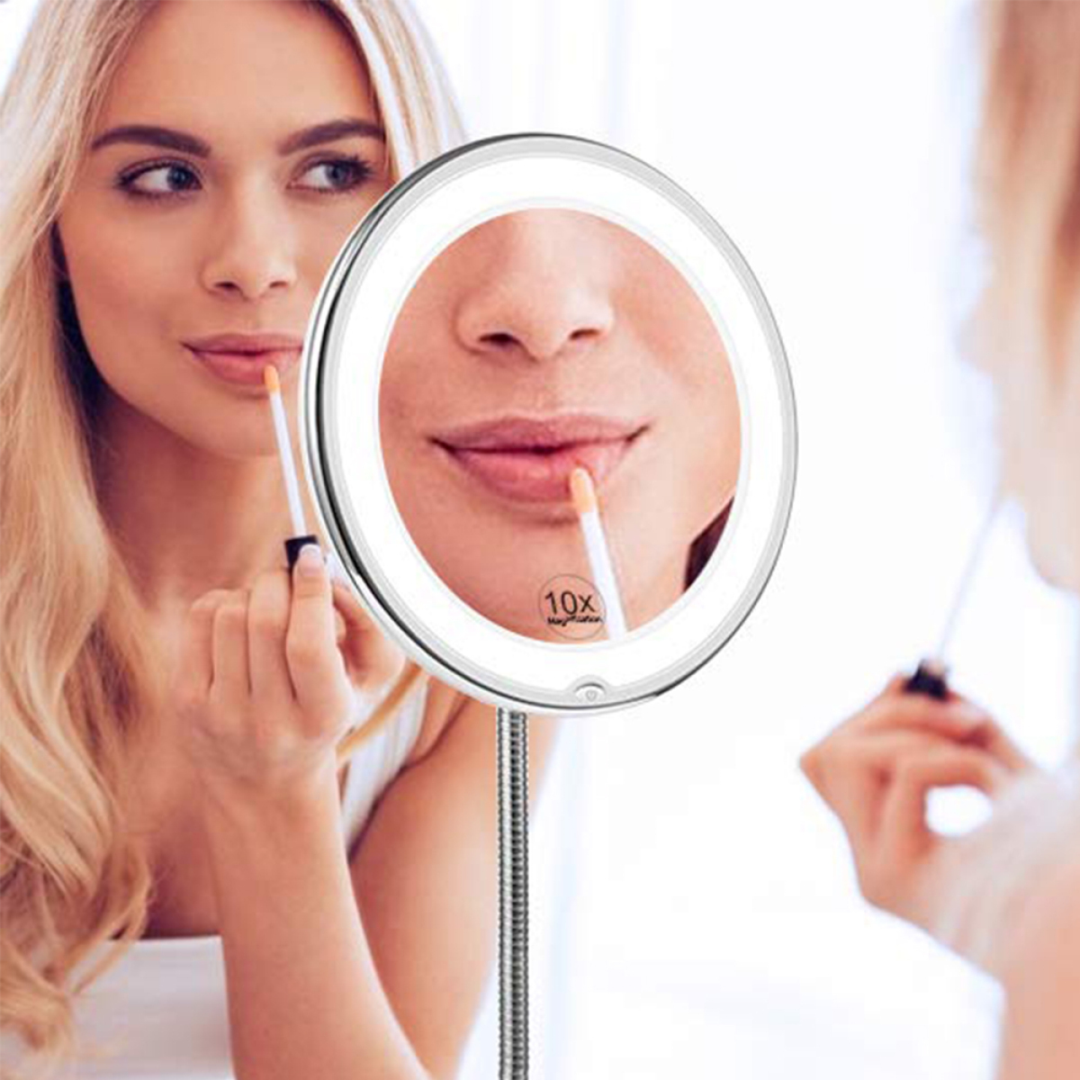 Frau, die Lipgloss in einem beleuchteten, runden Schminkspiegel aufträgt. Spiegelung zeigt ihr Gesicht.