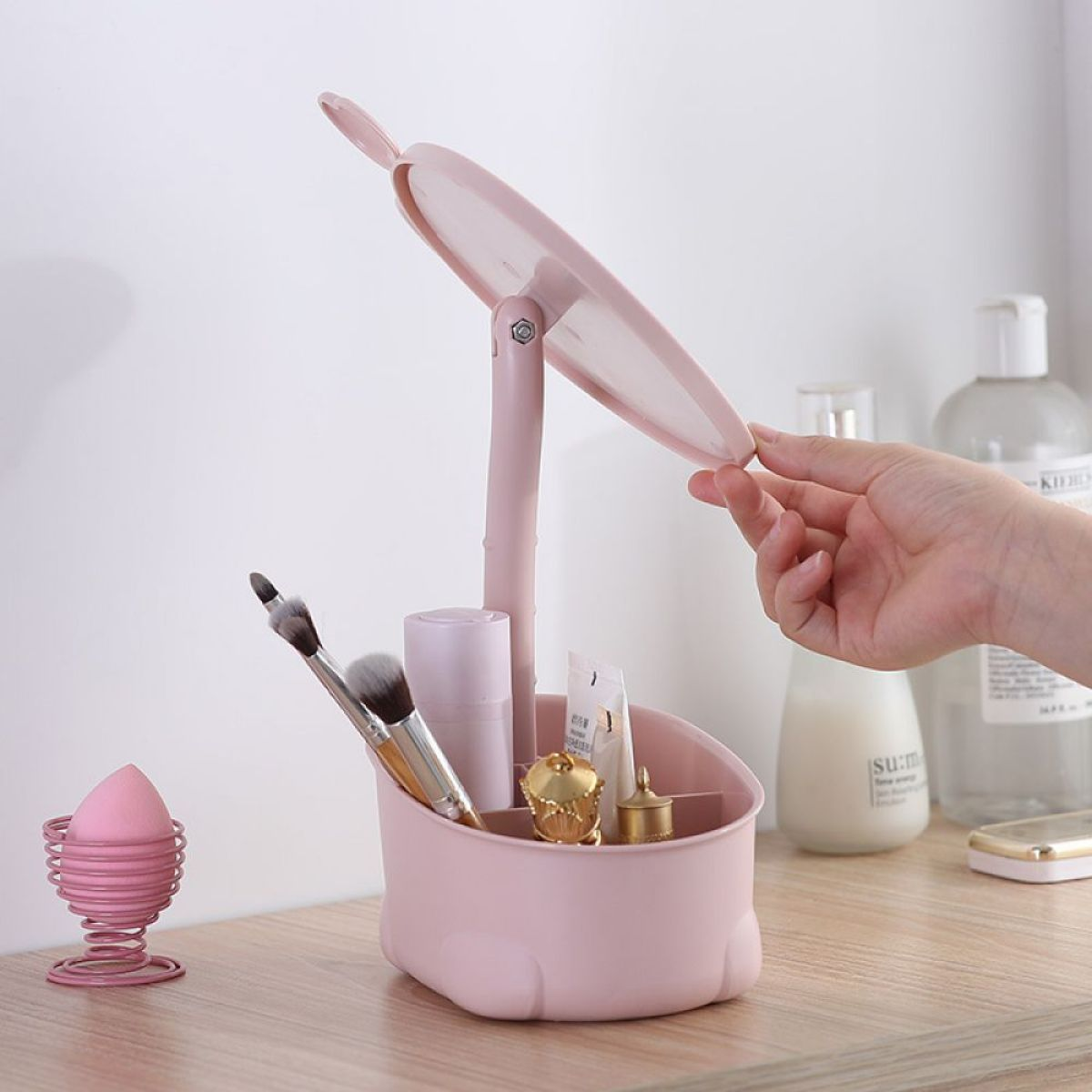 Rosa Make-up-Organizer mit Spiegel, Make-up-Pinseln und Schönheitsprodukten.