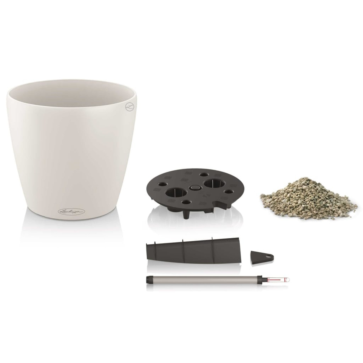 Pot de fleur blanc avec des composants. Socle noir, terre et autres pièces visibles.