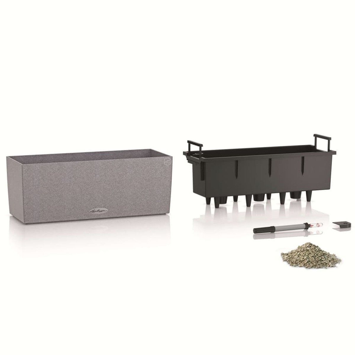 Zwei Pflanzgefäße, eines grau, eines schwarz, mit einem kleinen Steinhaufen und Werkzeugen.