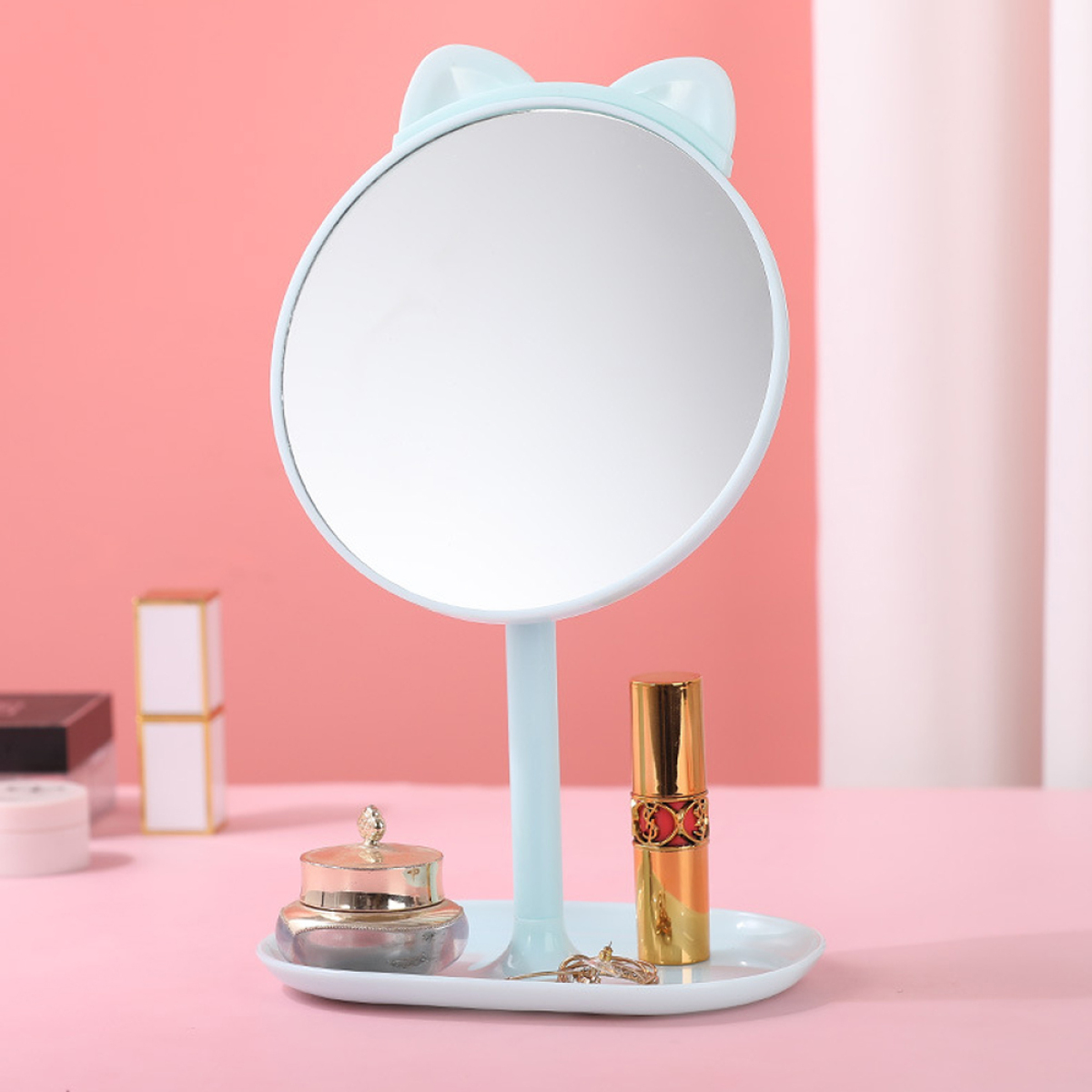 Katzenförmiger Spiegel mit Make-up-Artikeln auf der Basis.