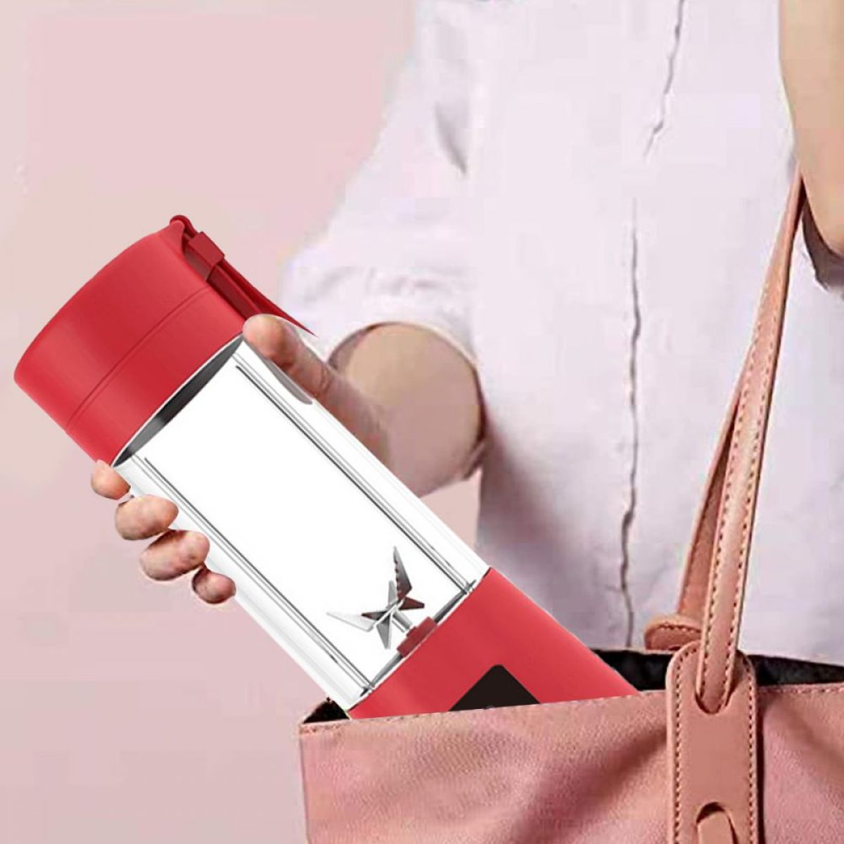 Eine Person, die einen rot-weißen Mixer in einer rosa Handtasche hält.