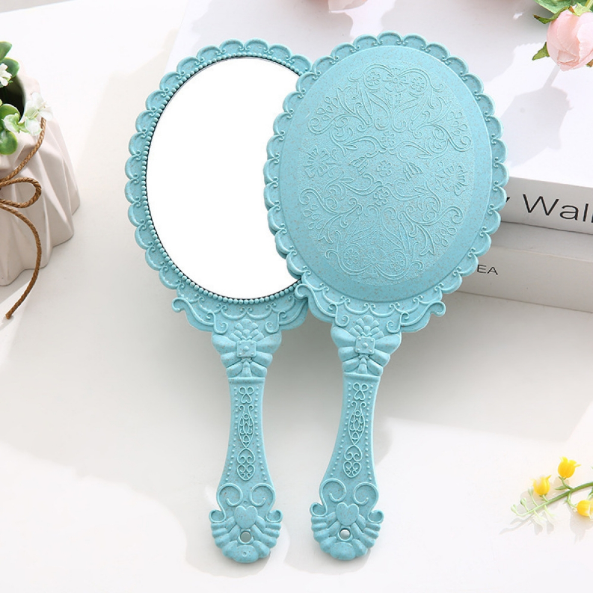 Zwei blaue Handspiegel, ovale Form mit Verzierungen und Griffen, auf weißer Oberfläche.