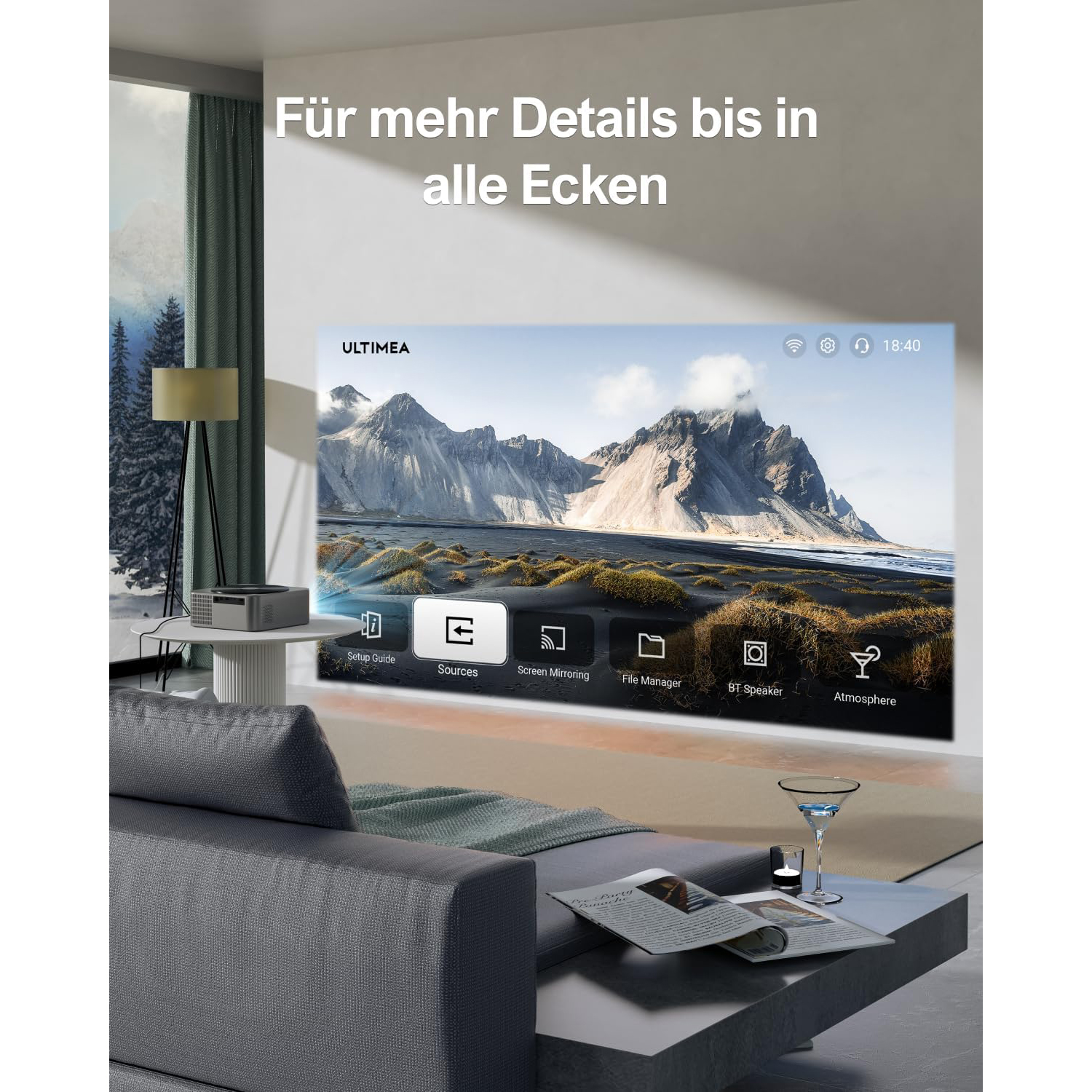 Wohnzimmerszene mit Projektor, der eine Landschaft zeigt, einem Sofa und einem Glas Getränk.