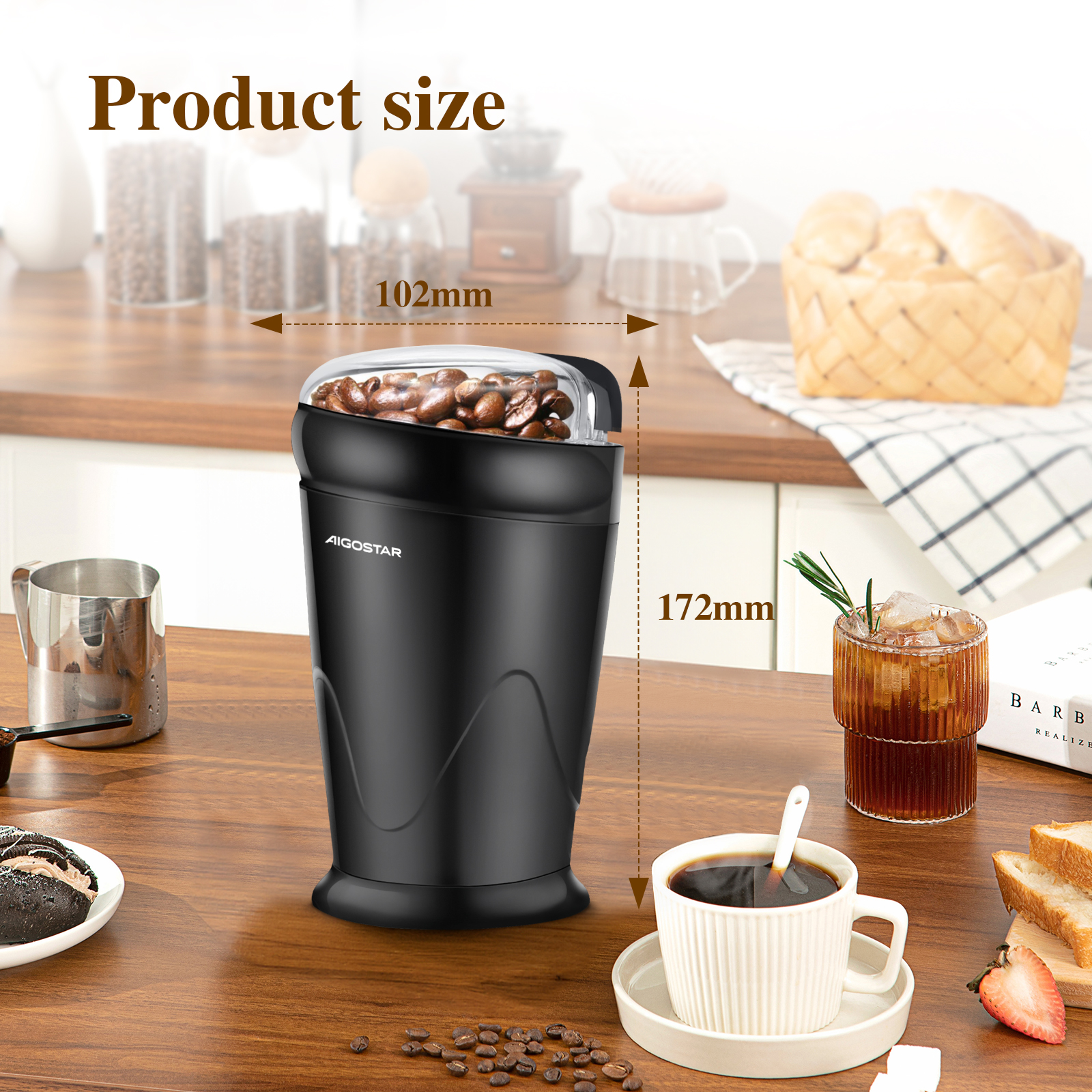 Molinillo de café negro con granos de café, una taza de café y otros artículos de cocina sobre una mesa de madera.